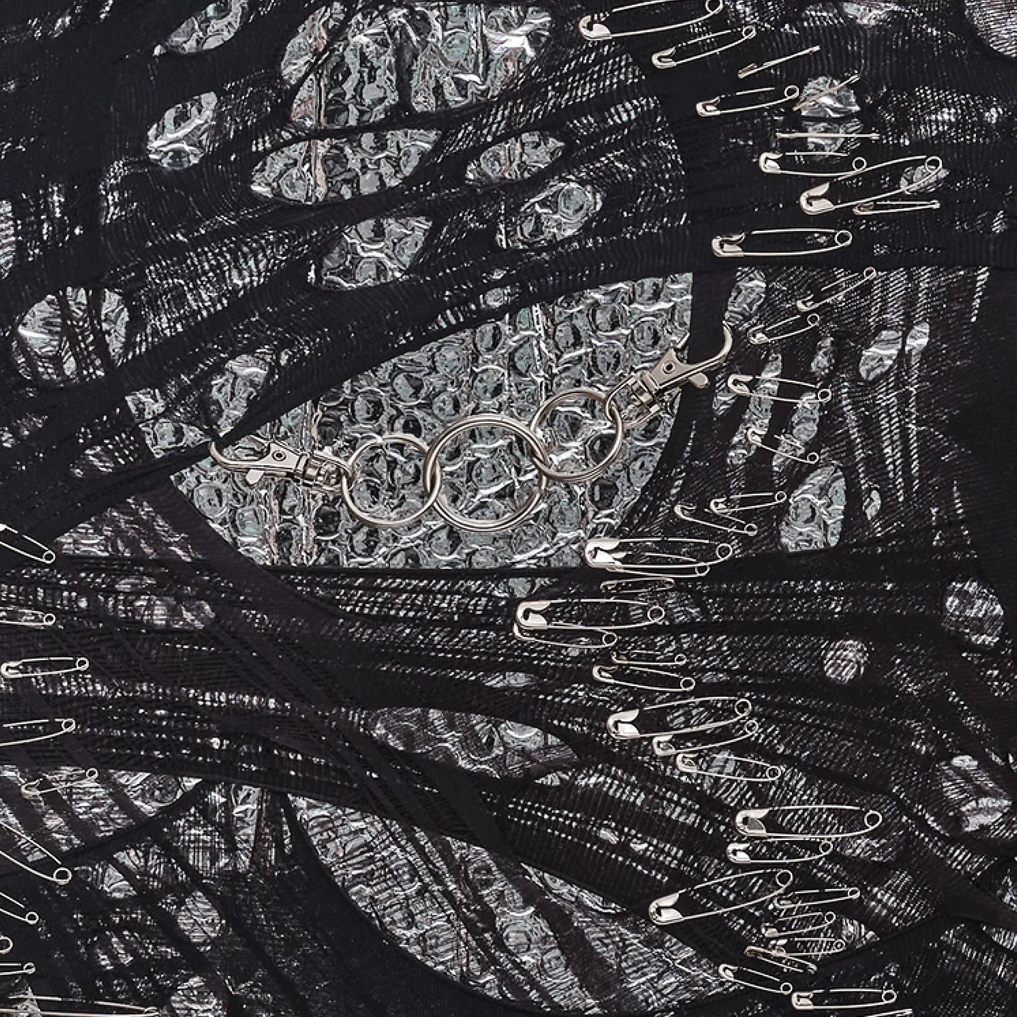 Detail of "Silver Dream" by Nicole Bajger, highlighting industrial textiles intersecting with reflective silver packaging.