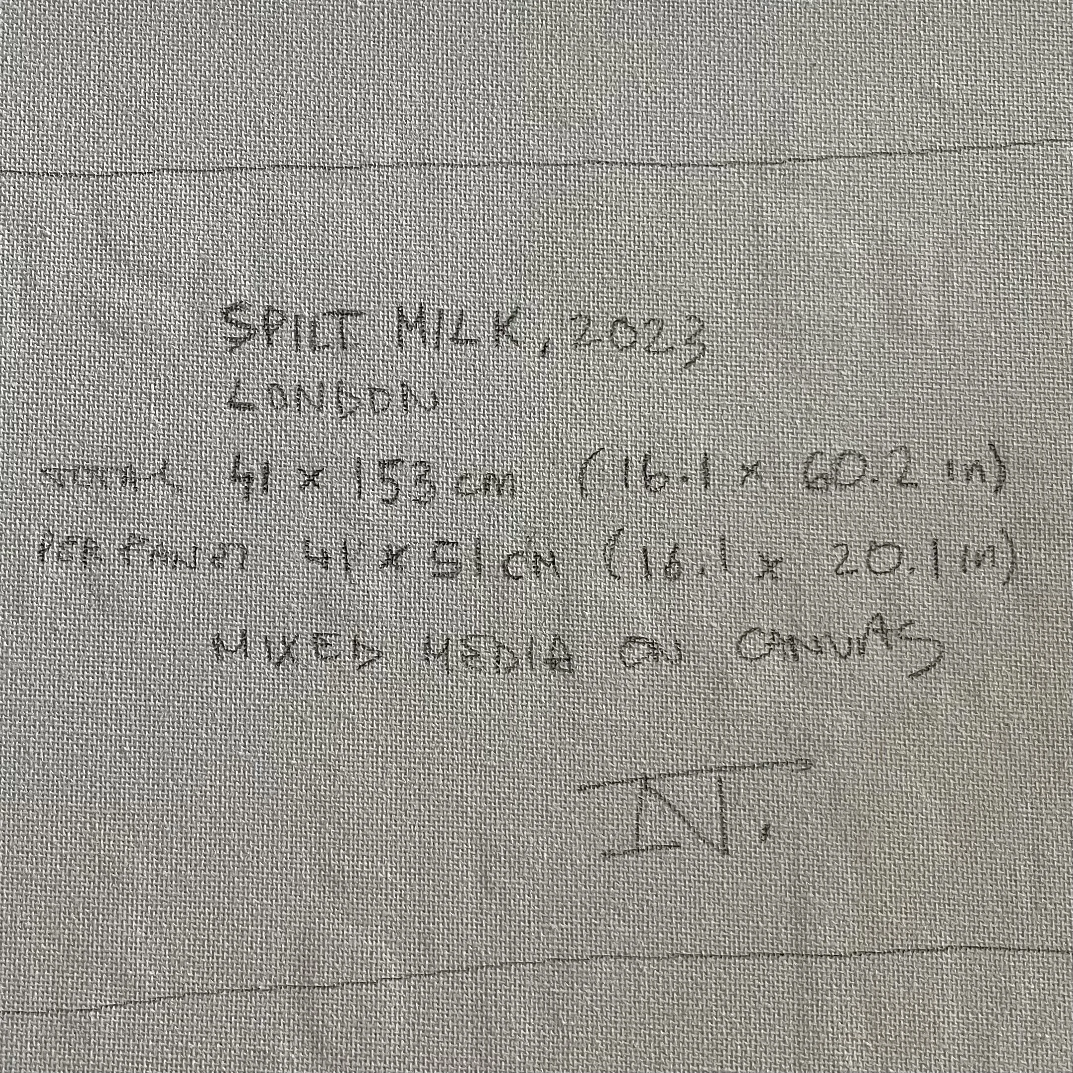 Close-up of gray fabric with handwritten text, partially visible, starting with 'SHINCH', on the fabric.