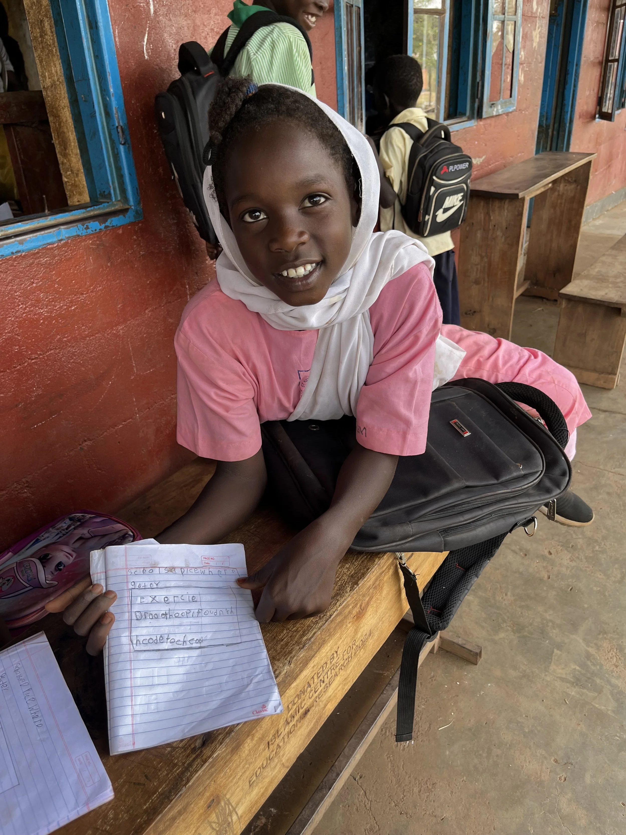 A young boy receiving books  for the school