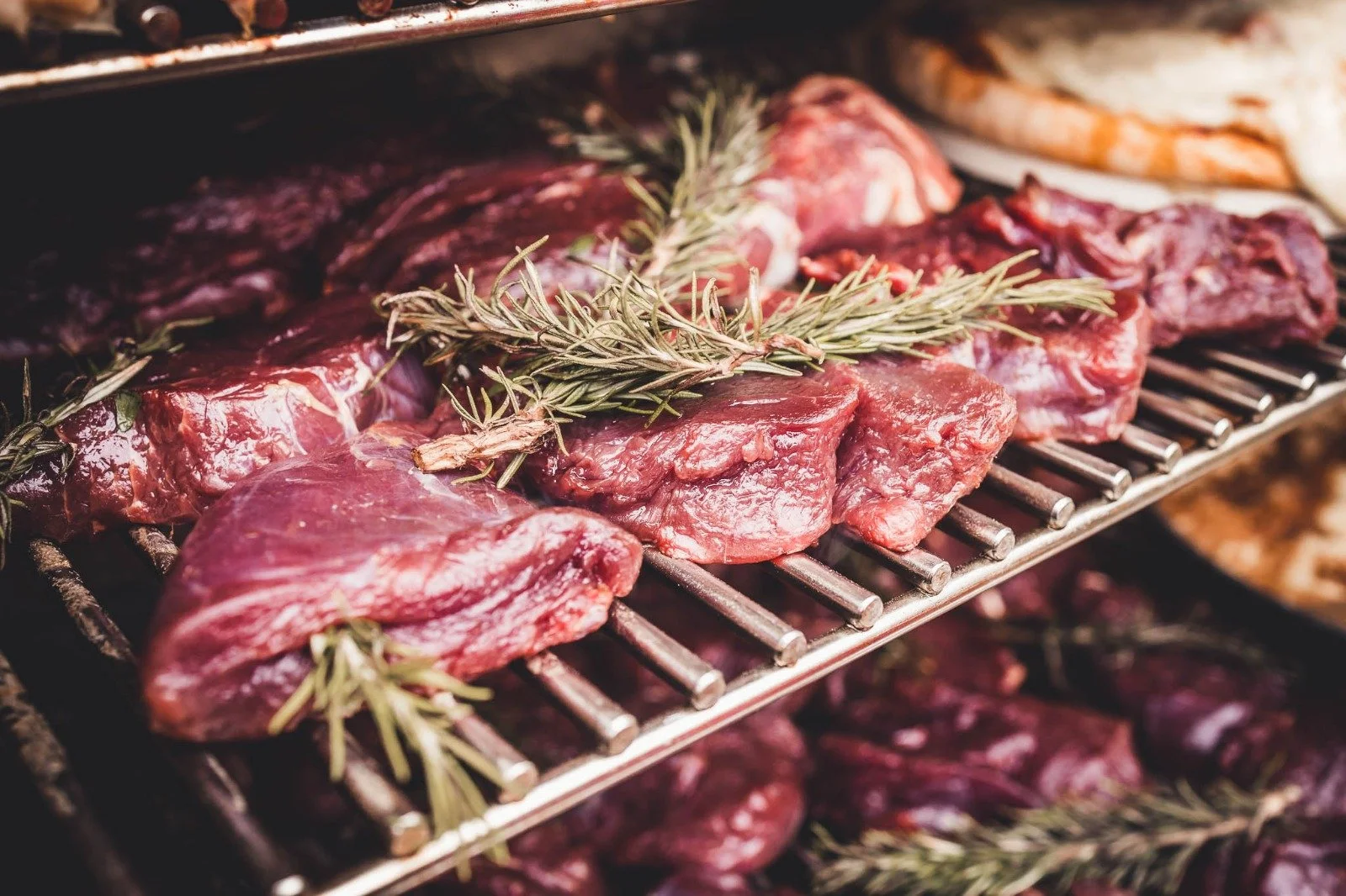 Rindfleischstücke mit Rosmarin auf einem Grillrost