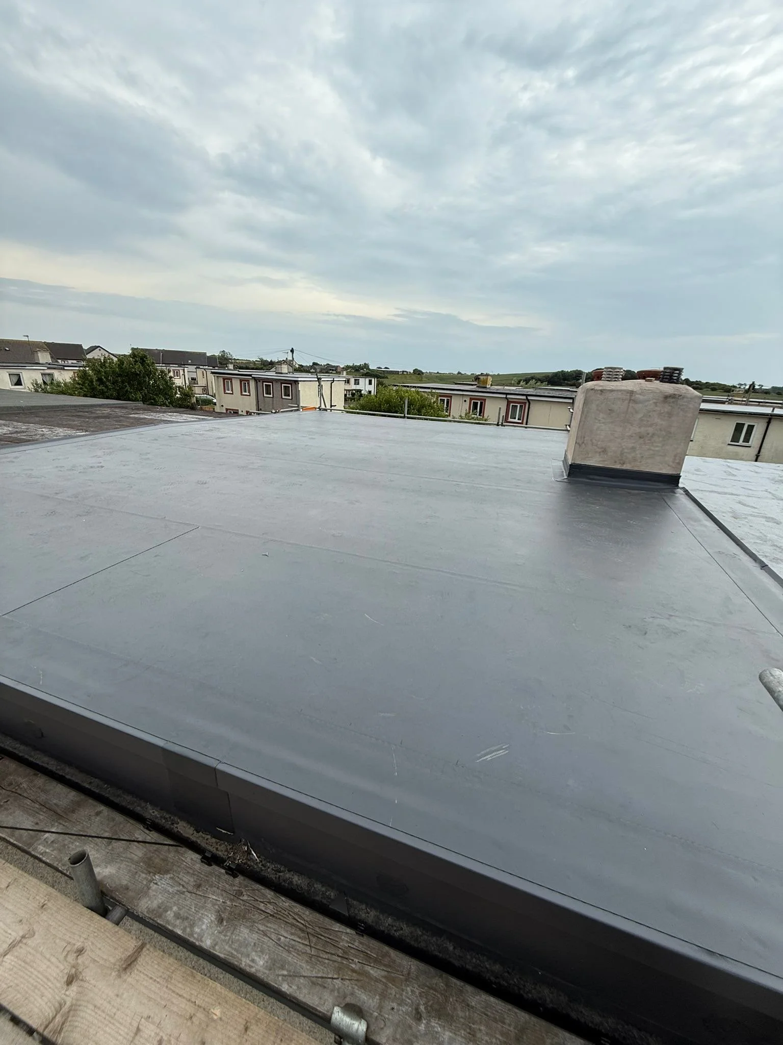 Precision-engineered wall upstand and crisp edge perimeter detailing on a completed flat roof replacement, ensuring zero water ingress pathways.
