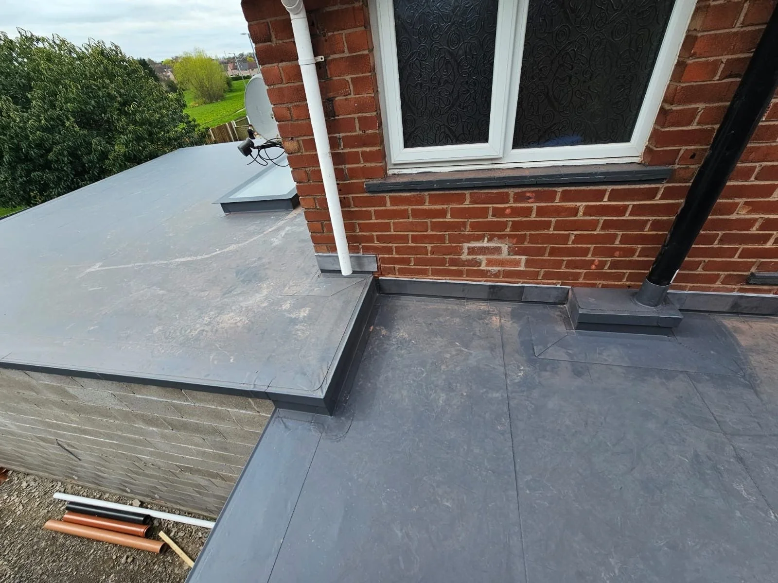 Close-up of expert corner welding and lead flashing on a modern flat roof in Cumbria.