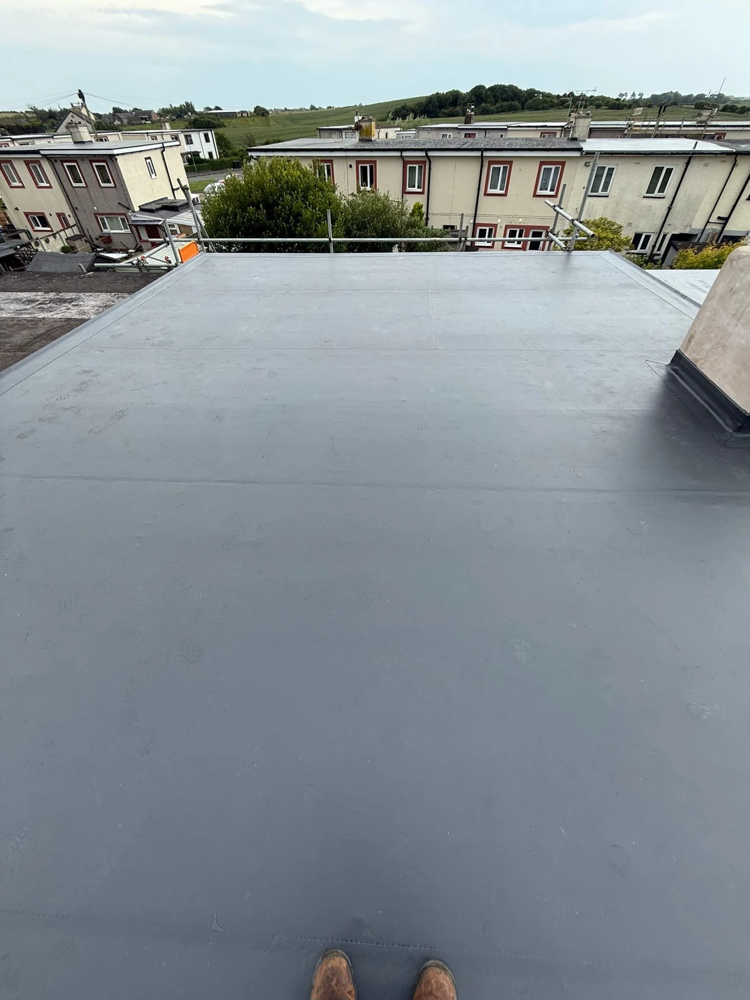 Finished flat roof deck showing flawless, hot-air welded seams that permanently fuse the sheets together, backed by a 25-year warranty.
