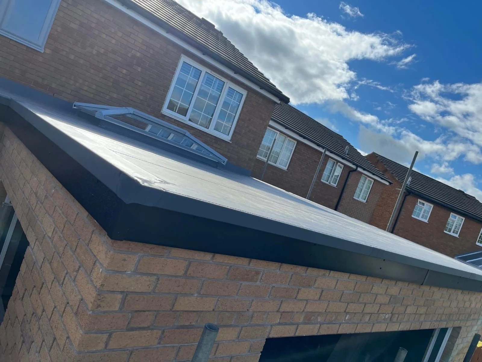 Wide angle view of a newly completed grey flat roof extension with integrated skylight in Carlisle.