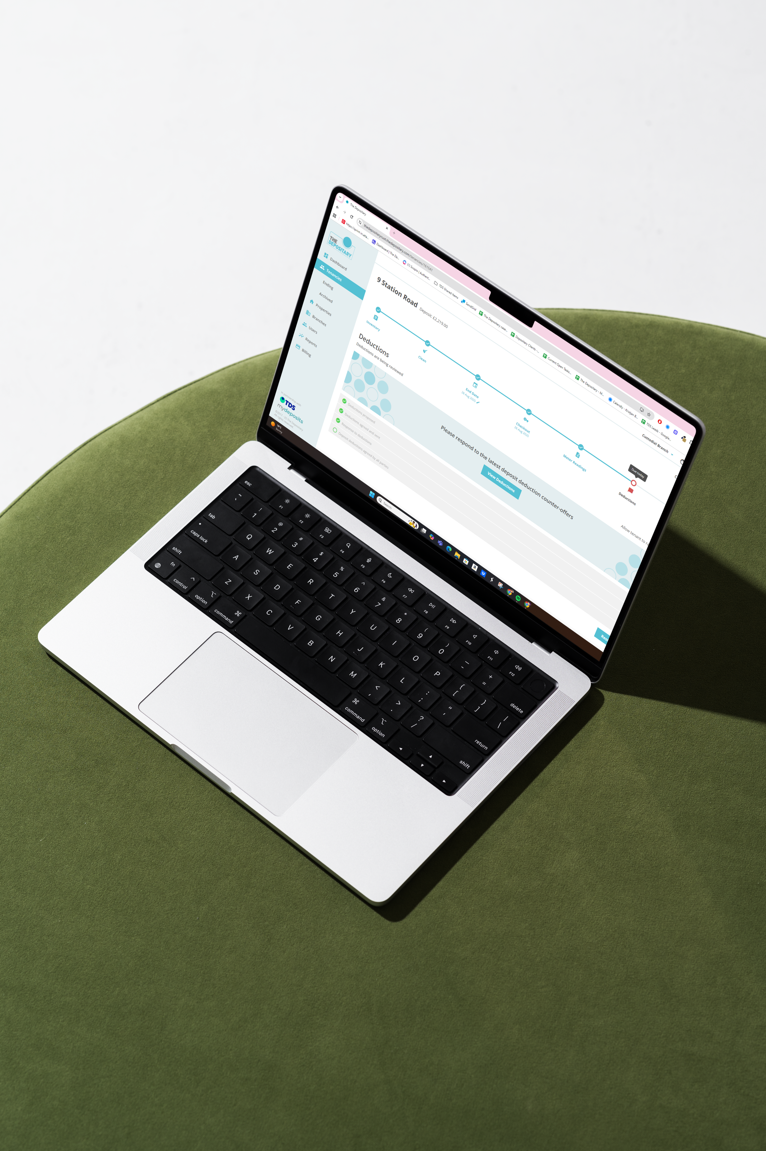 A laptop on a green surface displaying a webpage related to deposits and deductions.