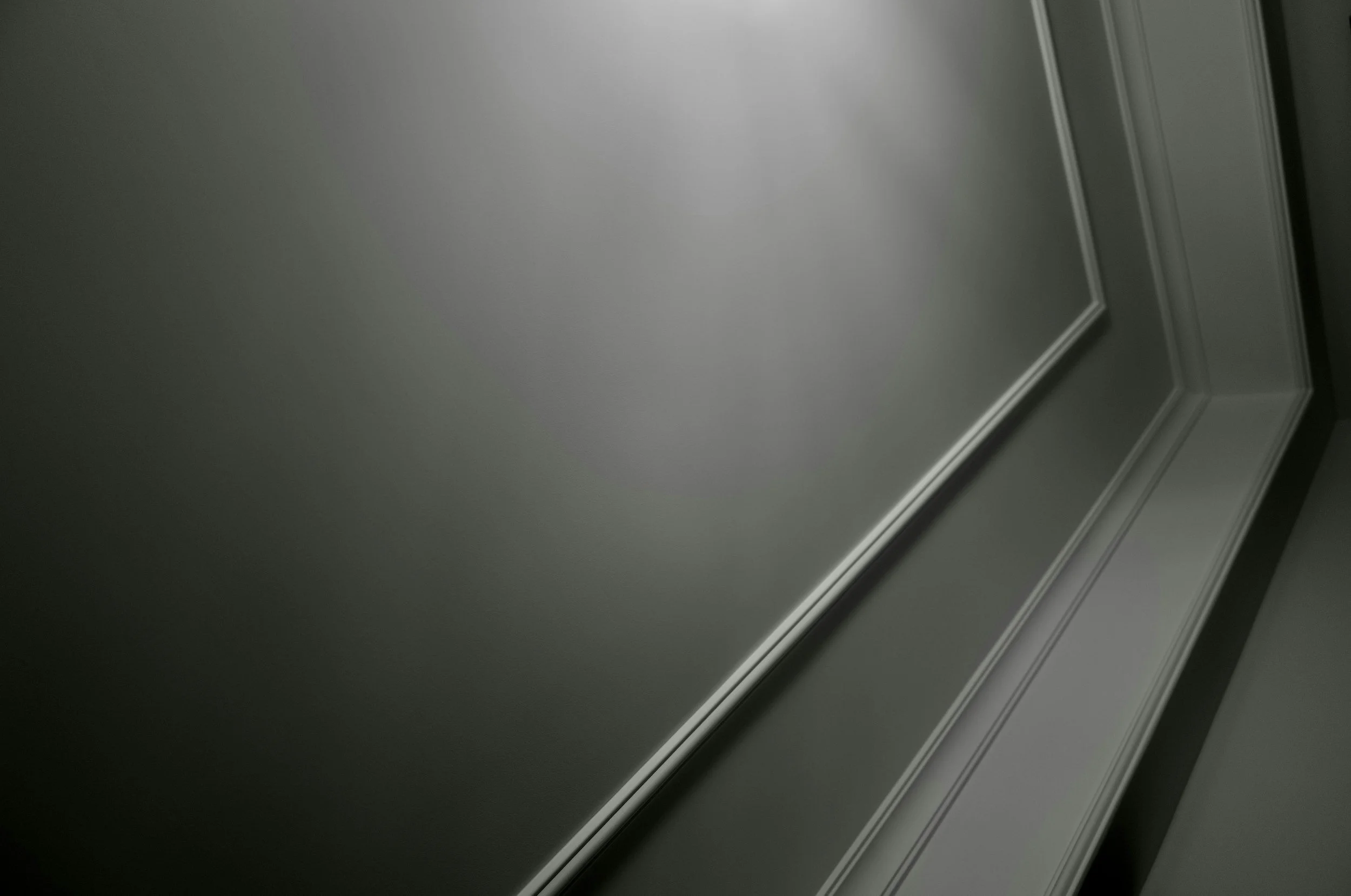 The image shows a gray wall with decorative white trim and molding near the ceiling.