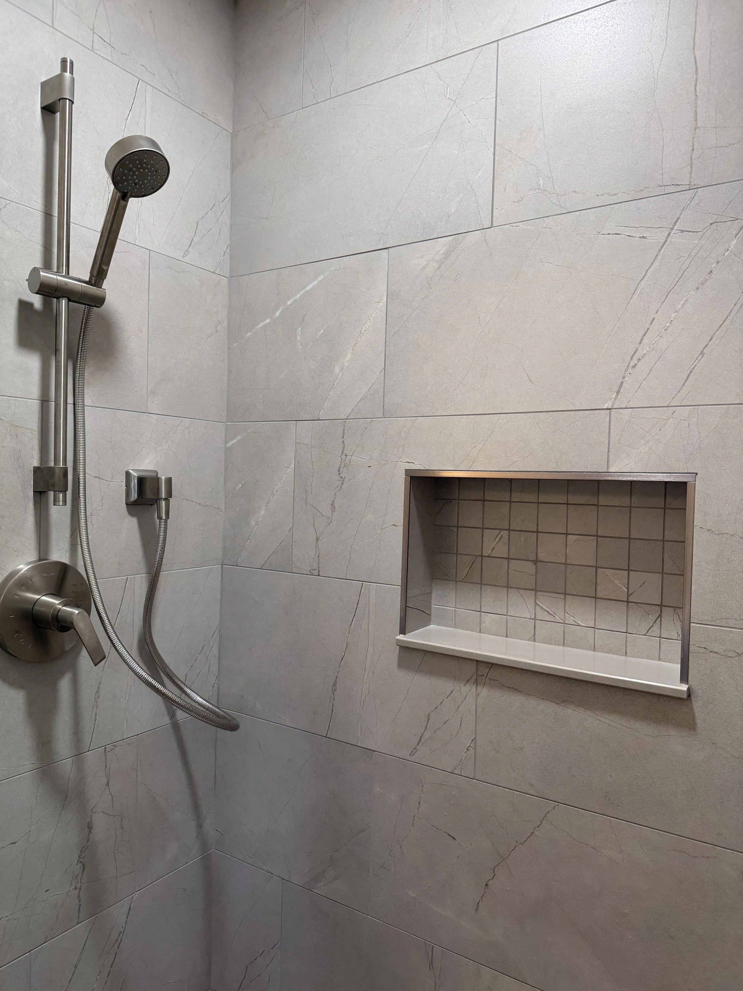 Completed primary bathroom remodel featuring custom shower and tile flooring in Brick NJ