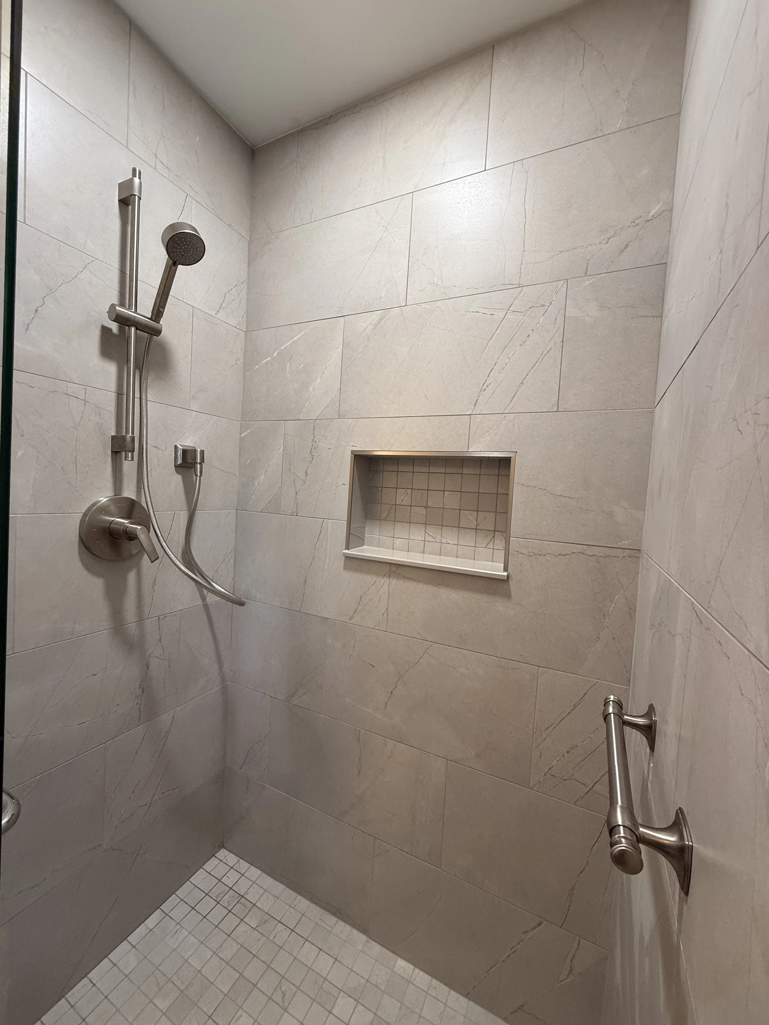Completed primary bathroom remodel featuring custom shower and tile flooring in Brick NJ