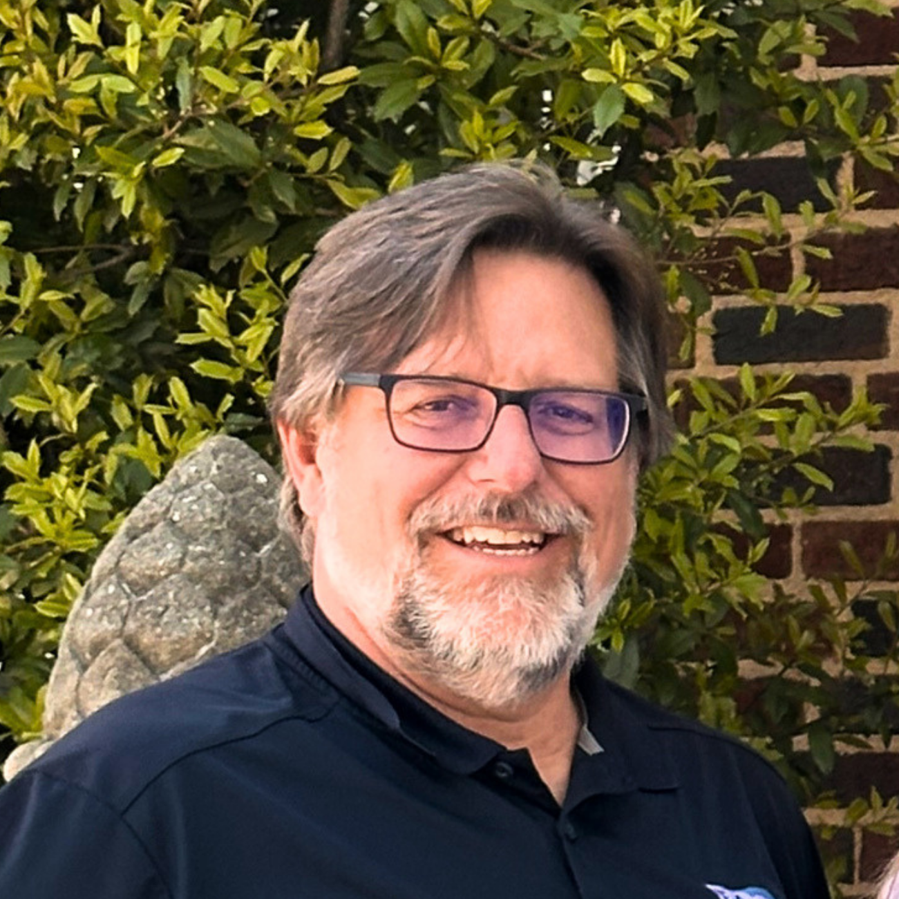 Headshot of smiling male tutor with short brown hair and glasses
