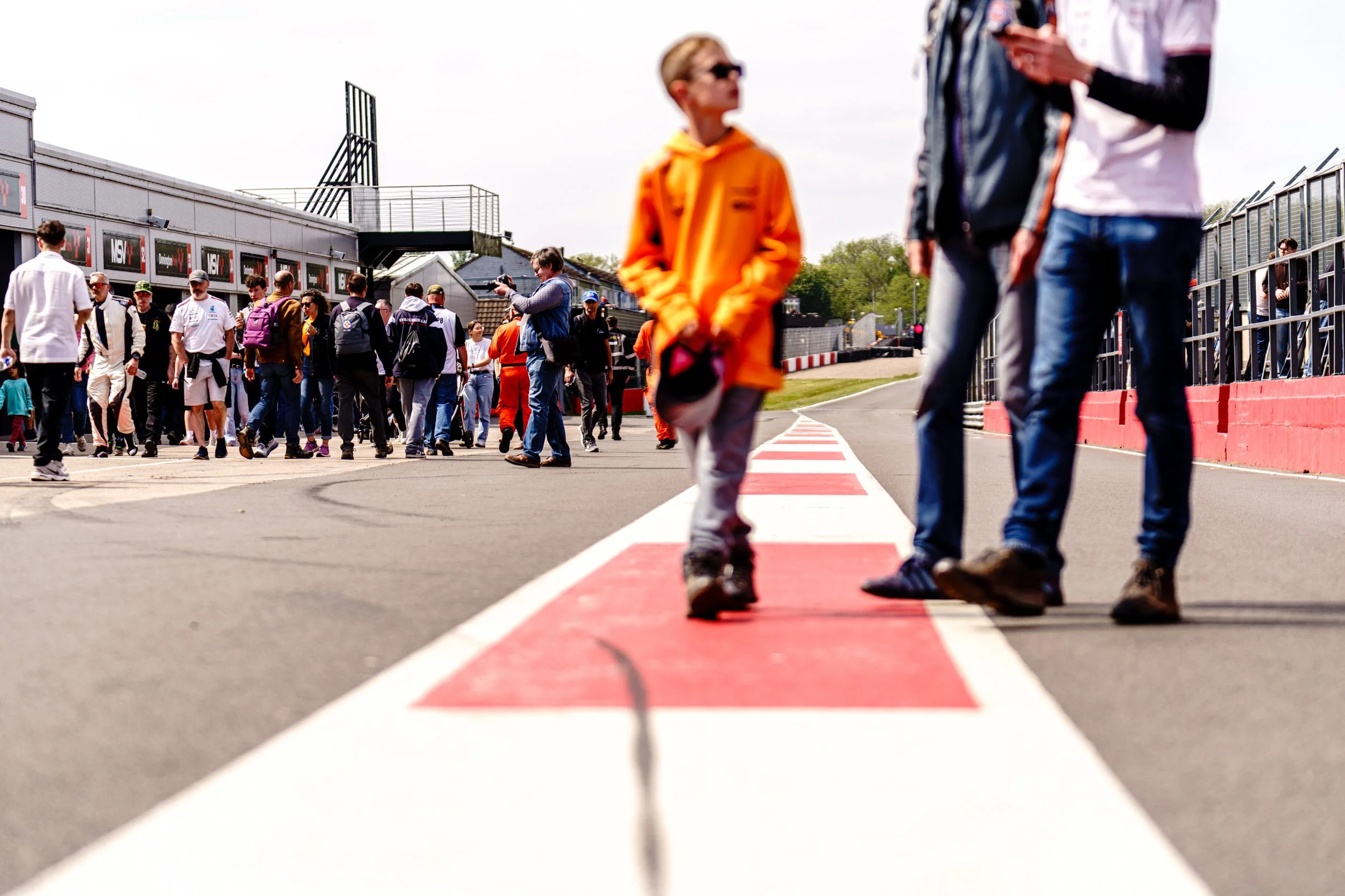 Marshal in orange overalls standing in the Donington Park pit lane.