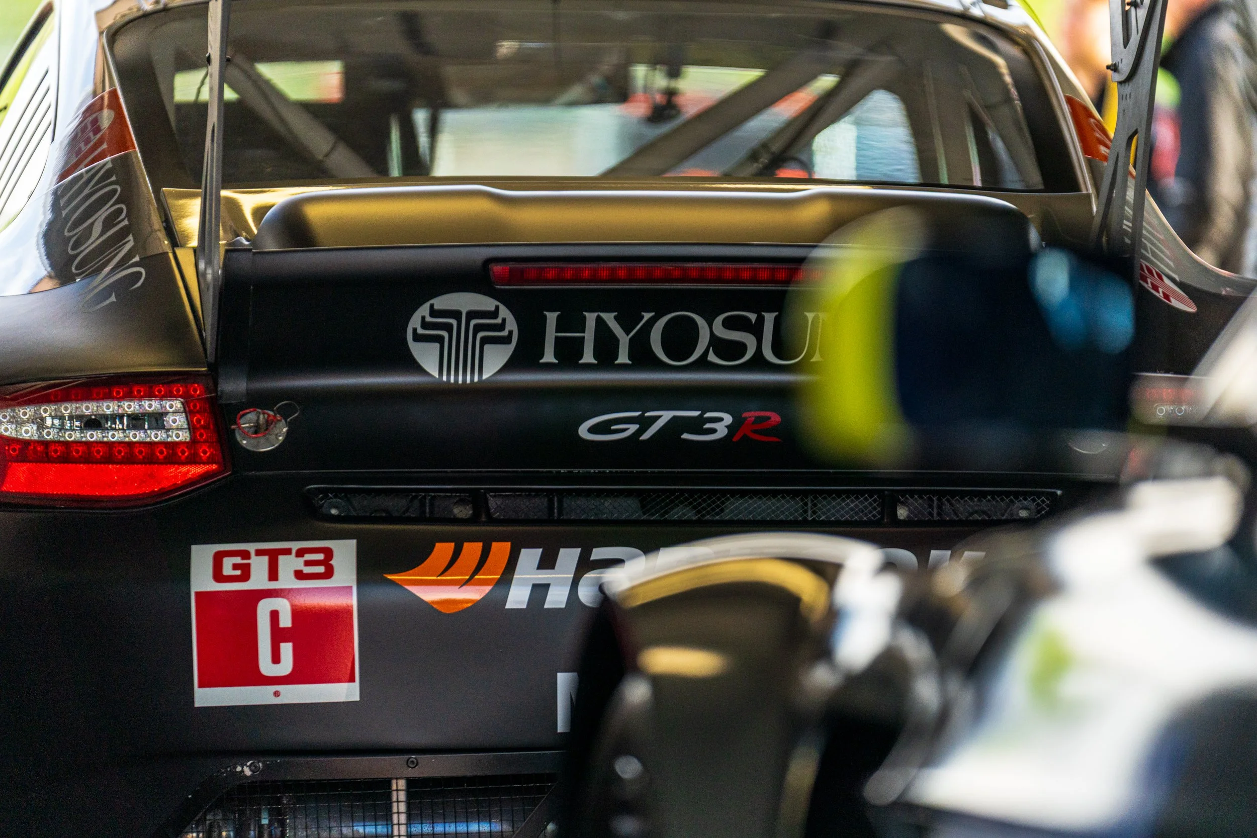 Rear view of a Triumph racing car in the Donington paddock.
