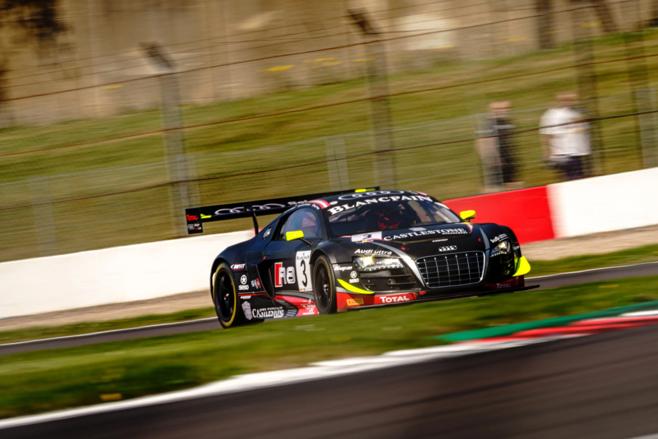 Black GT racing car taking a corner at Donington Park.