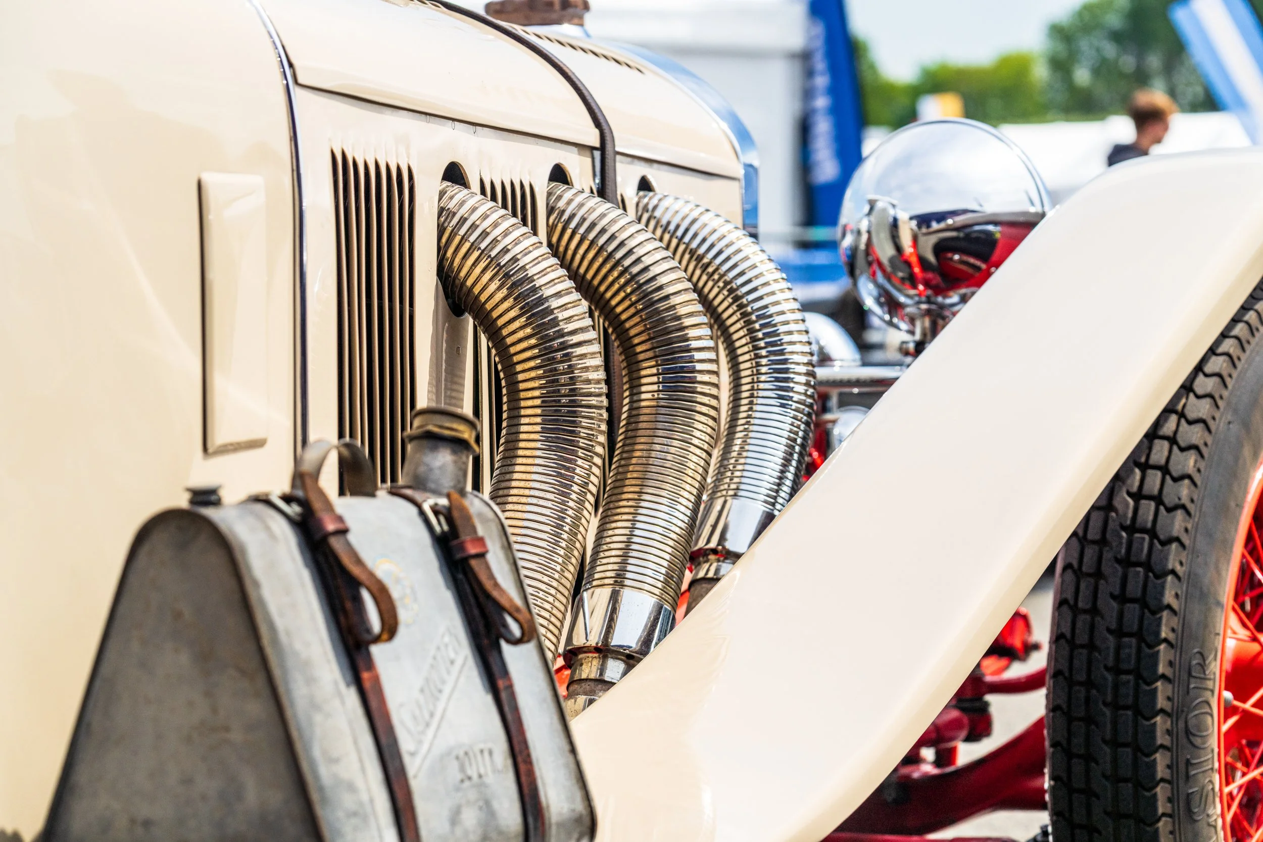Exposed exhaust pipes along the side of a classic racing car in the Donington paddock.