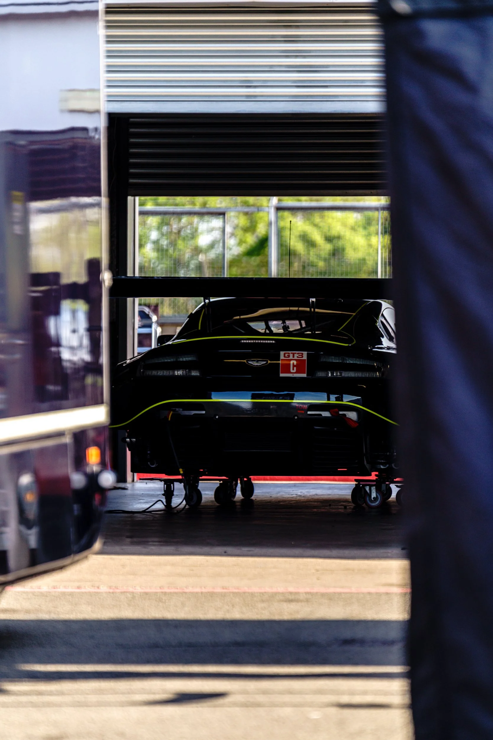 Rear of a racing car framed by an open pit garage at Donington Park.