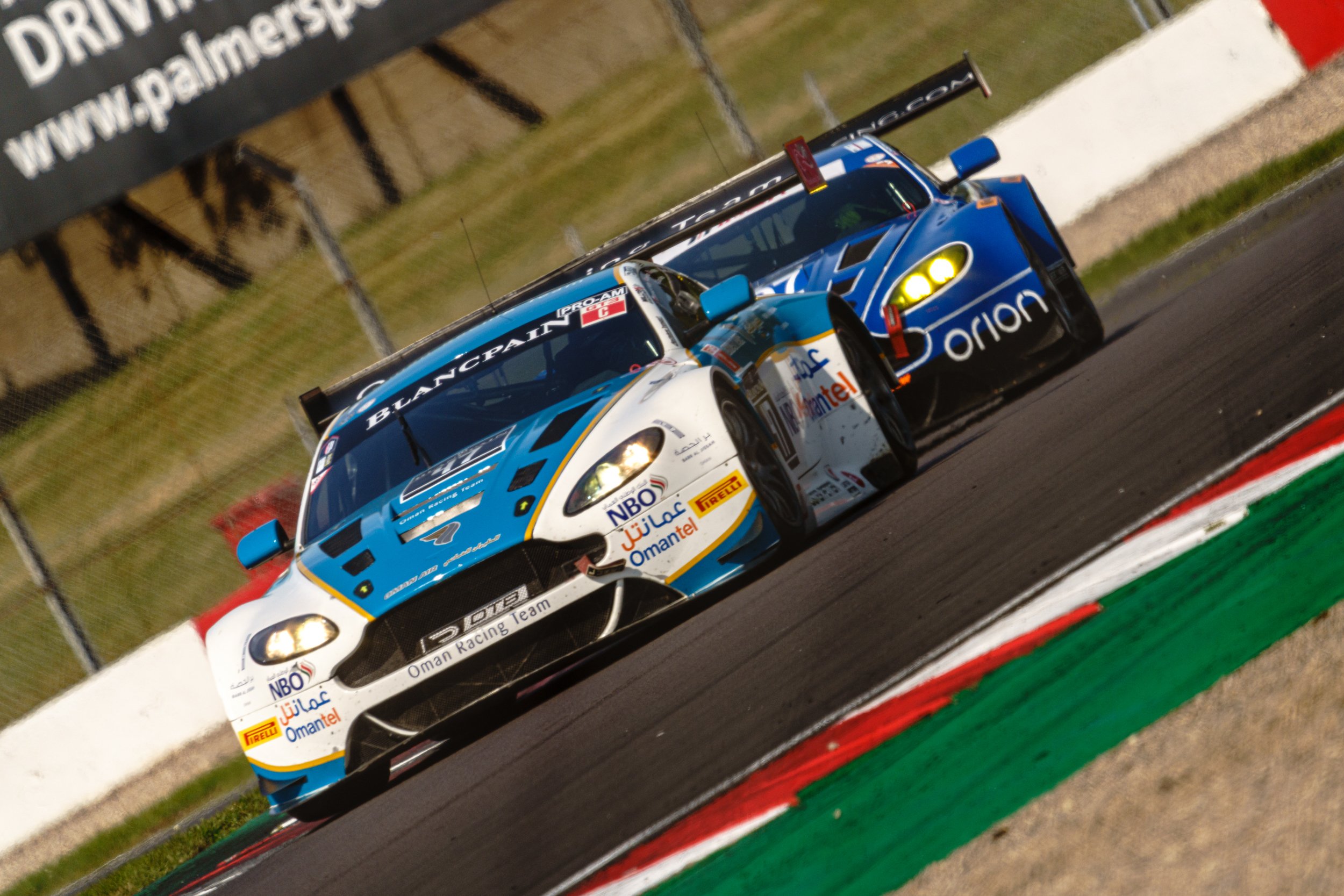 White and blue GT racing cars competing at Donington Historic Festival.
