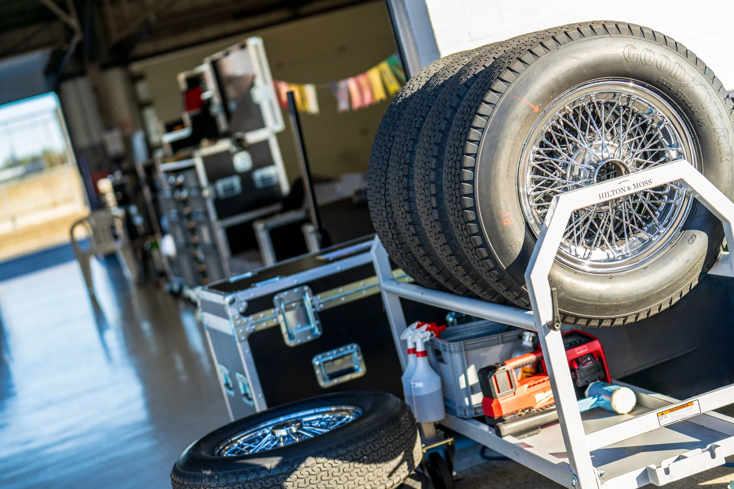 Racing wheels, tyres and equipment stacked in the Silverstone paddock.
