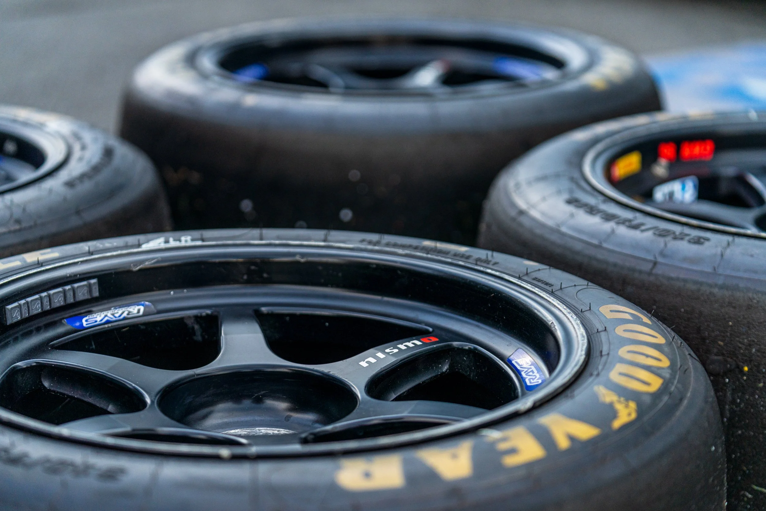 Racing wheels and tyres stacked in the Donington Historic Festival paddock.
