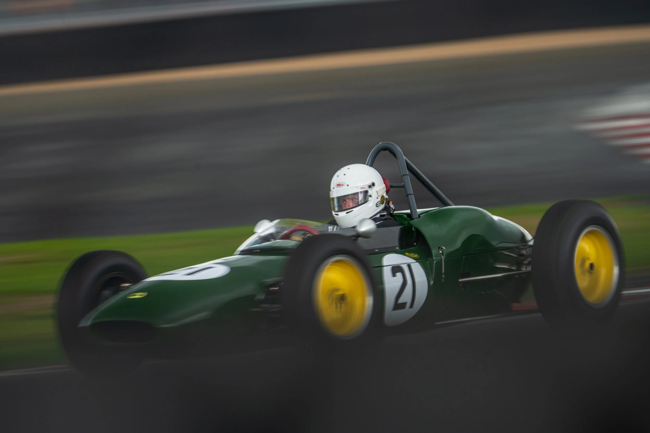 Green classic single-seater captured at speed at Silverstone.