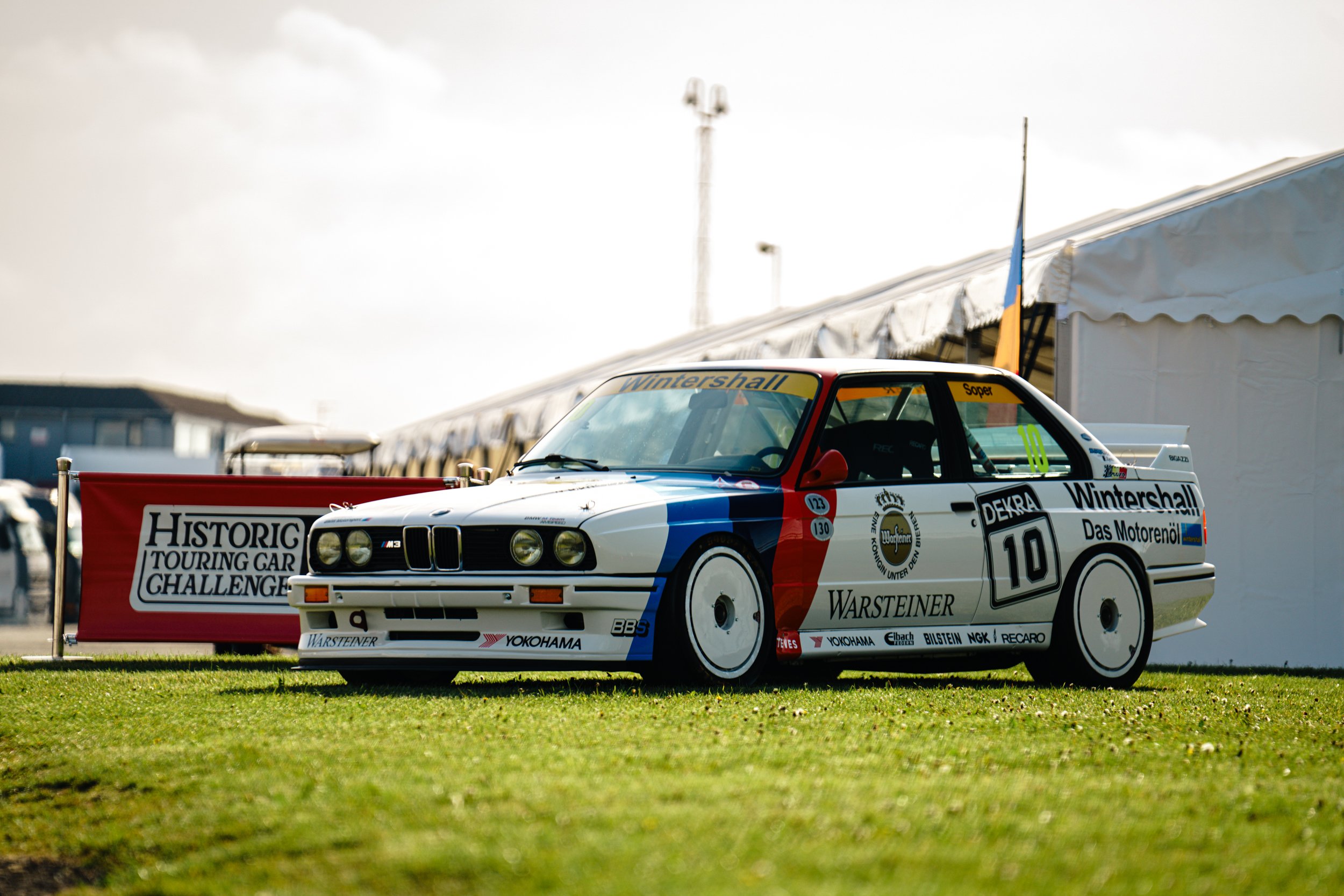 White, blue and red BMW touring car number 10 in the Donington Historic Festival paddock.