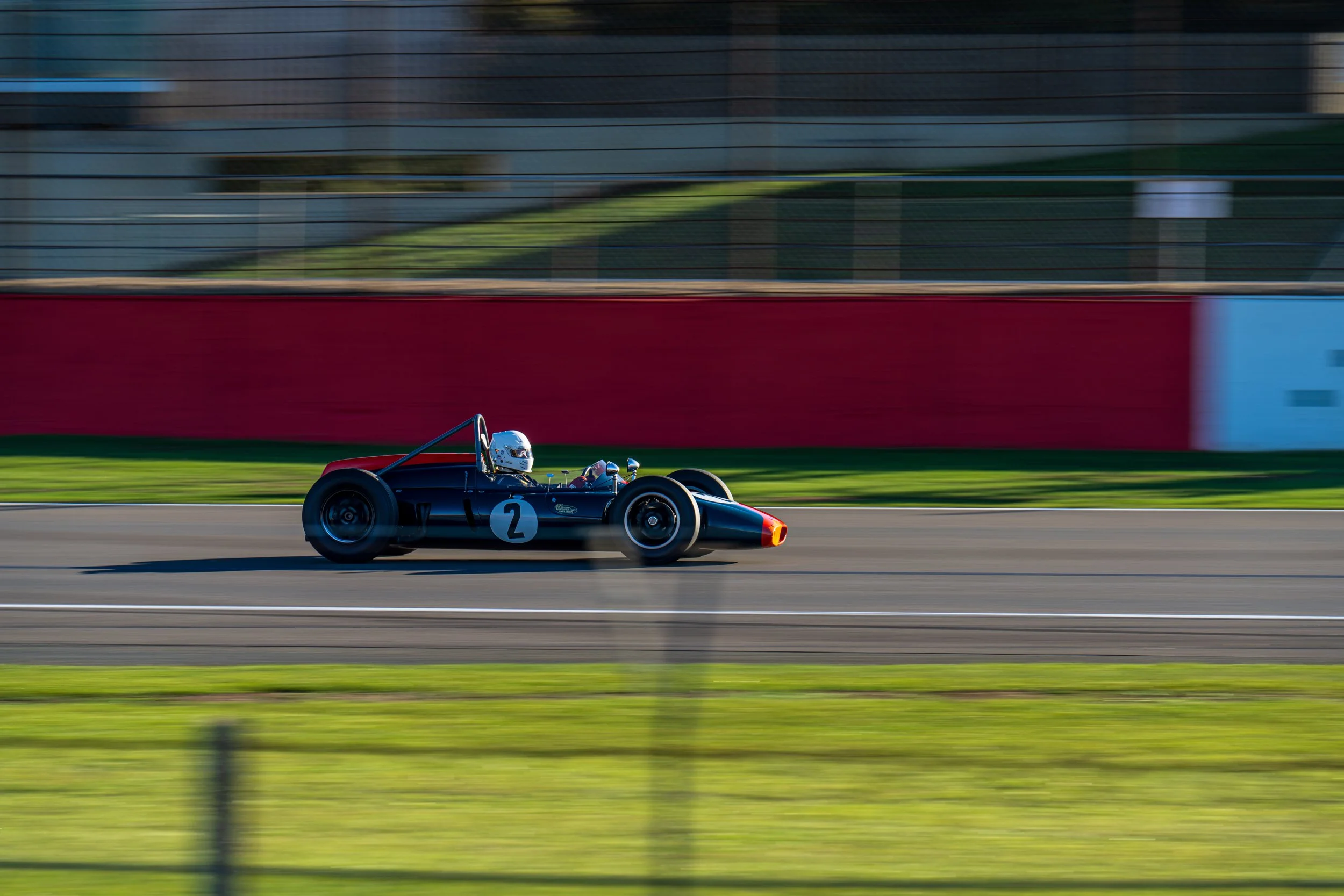 Blue classic single-seater number 2 captured at speed on the Silverstone Grand Prix circuit.
