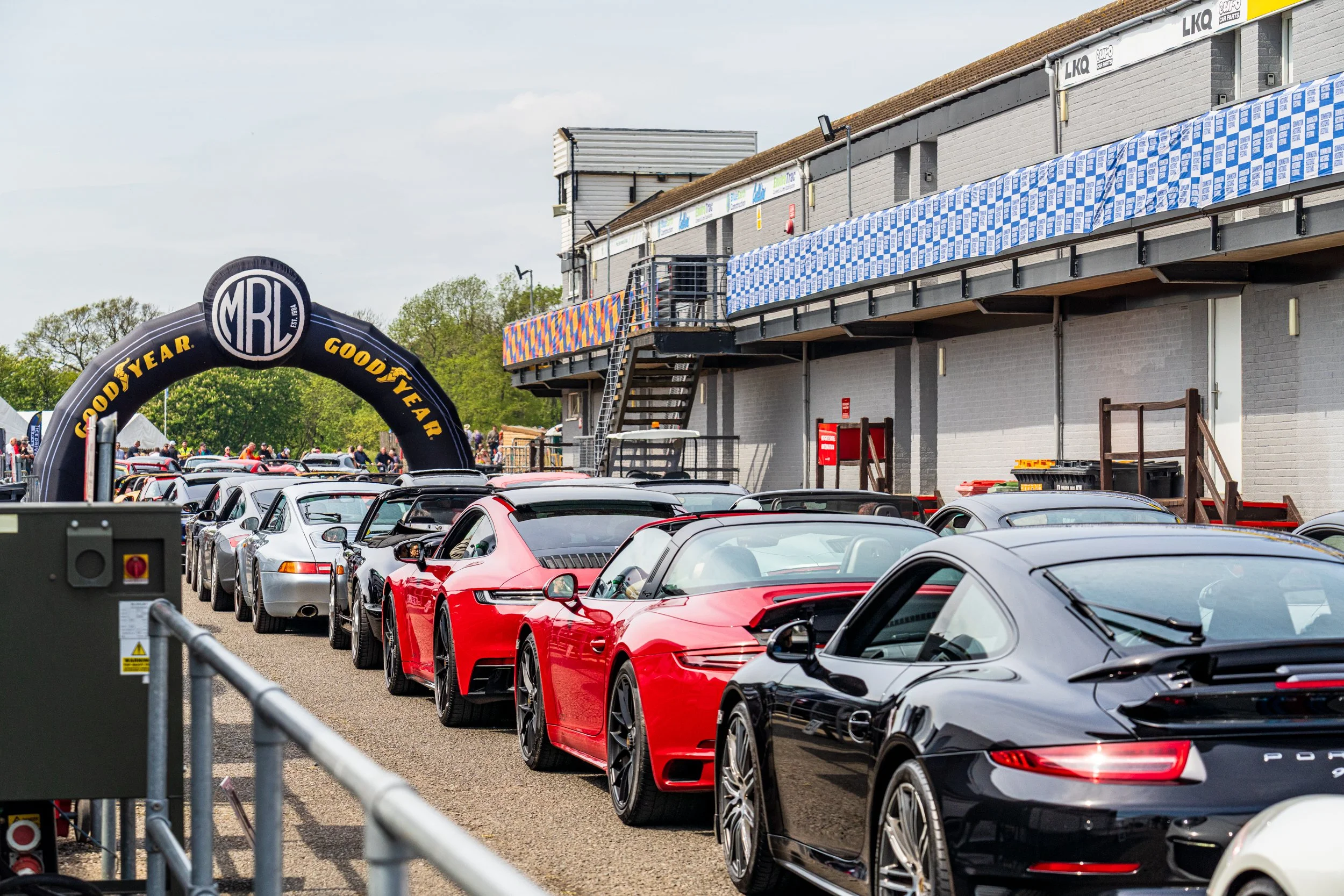 Line of racing cars beside the Donington Park pit building.