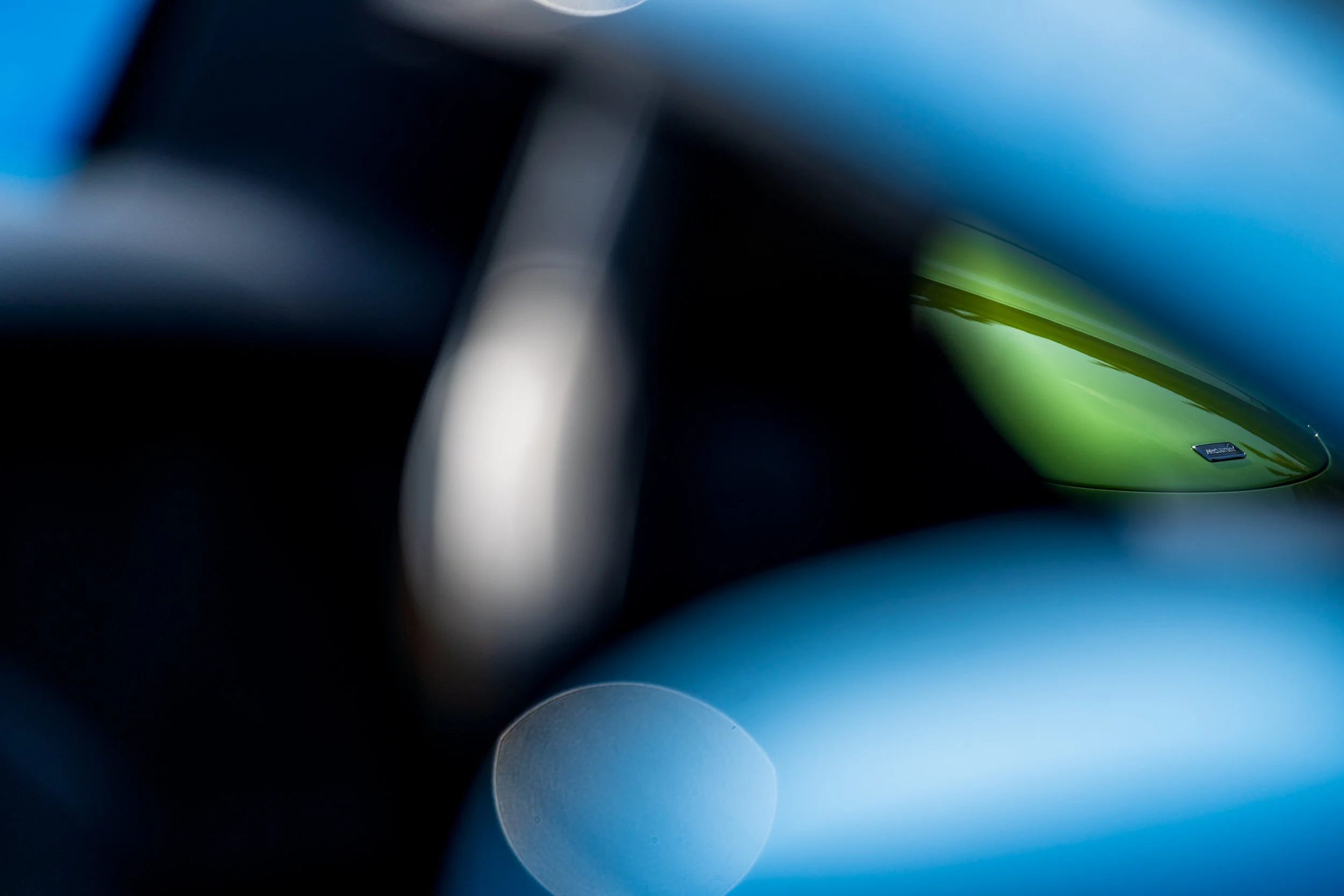 Close-up of colorful, blurred abstract shapes with a small badge on a green surface.