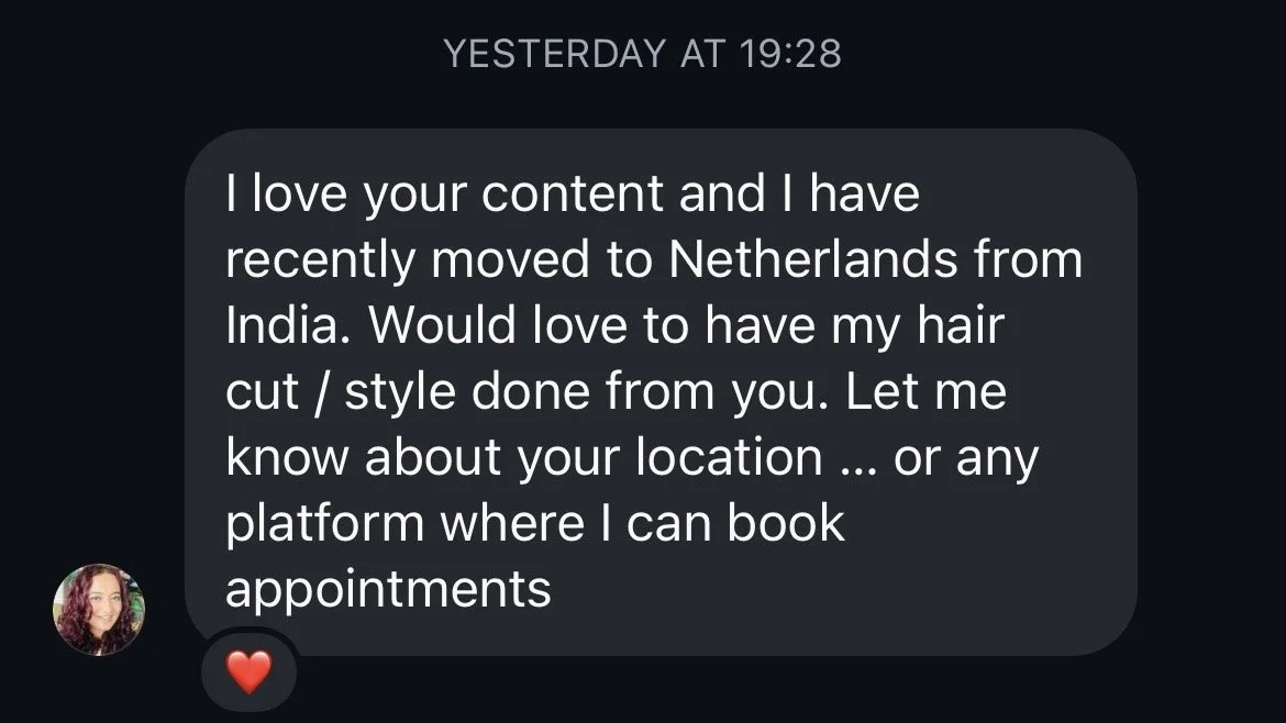 Screenshot of a text message conversation on a mobile device. The message expresses love for content and mentions moving to the Netherlands from India. It requests a haircut or styling appointment and asks for the recipient's location or platform to book appointments. The message includes a red heart emoji.