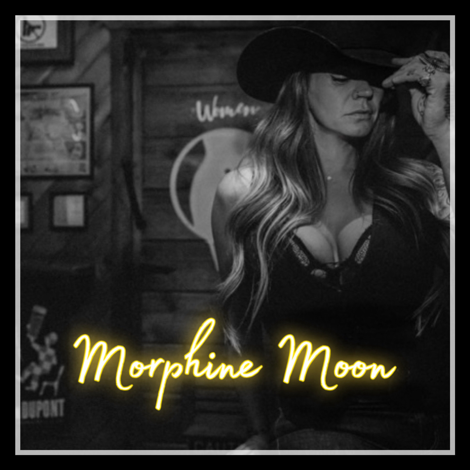 A woman with long wavy hair wearing a black hat, sitting in a wooden interior, with neon text reading 'Morning Moon' at the bottom of the image.