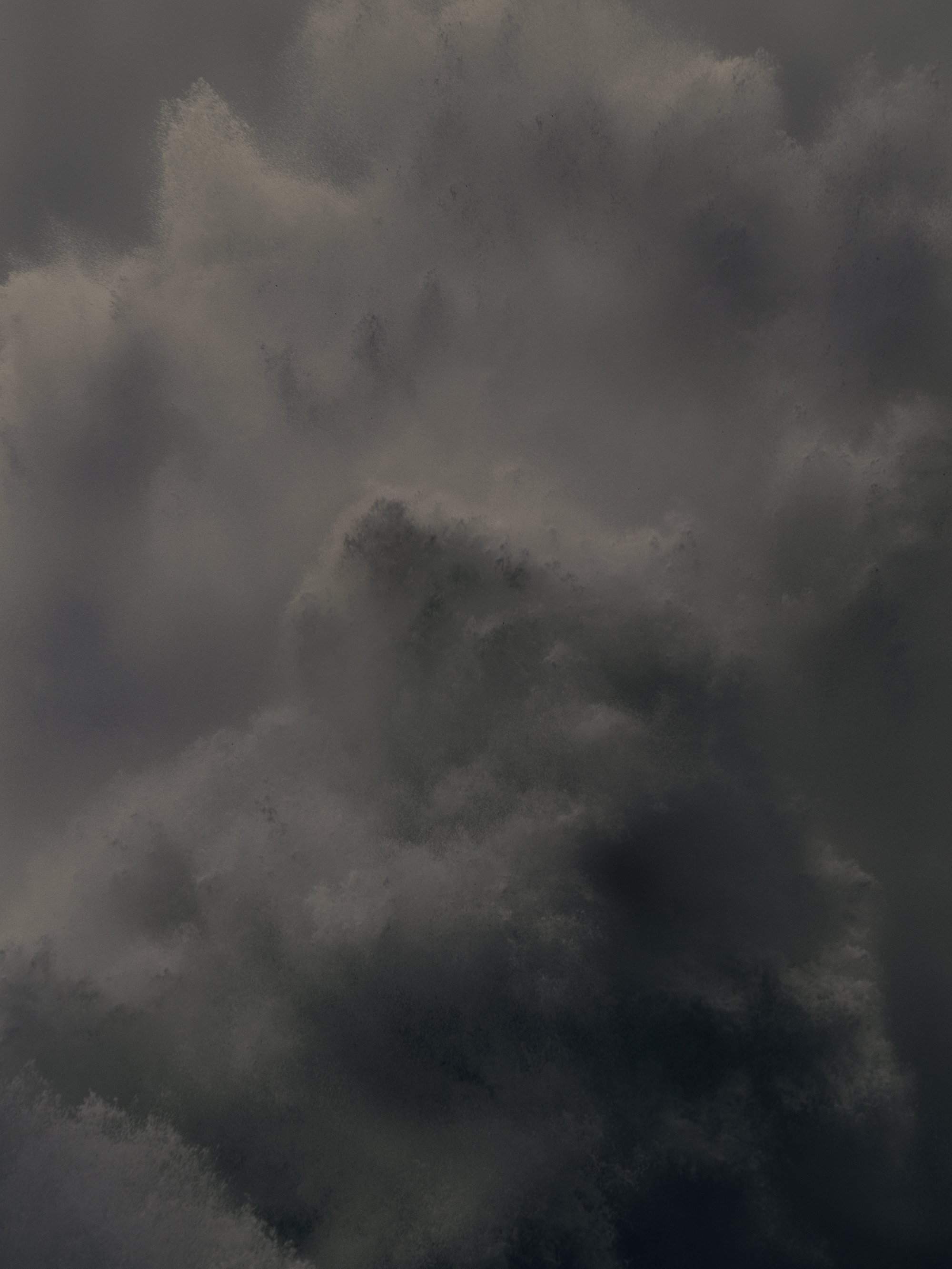 Dark cloudy sky with patches of lighter clouds.