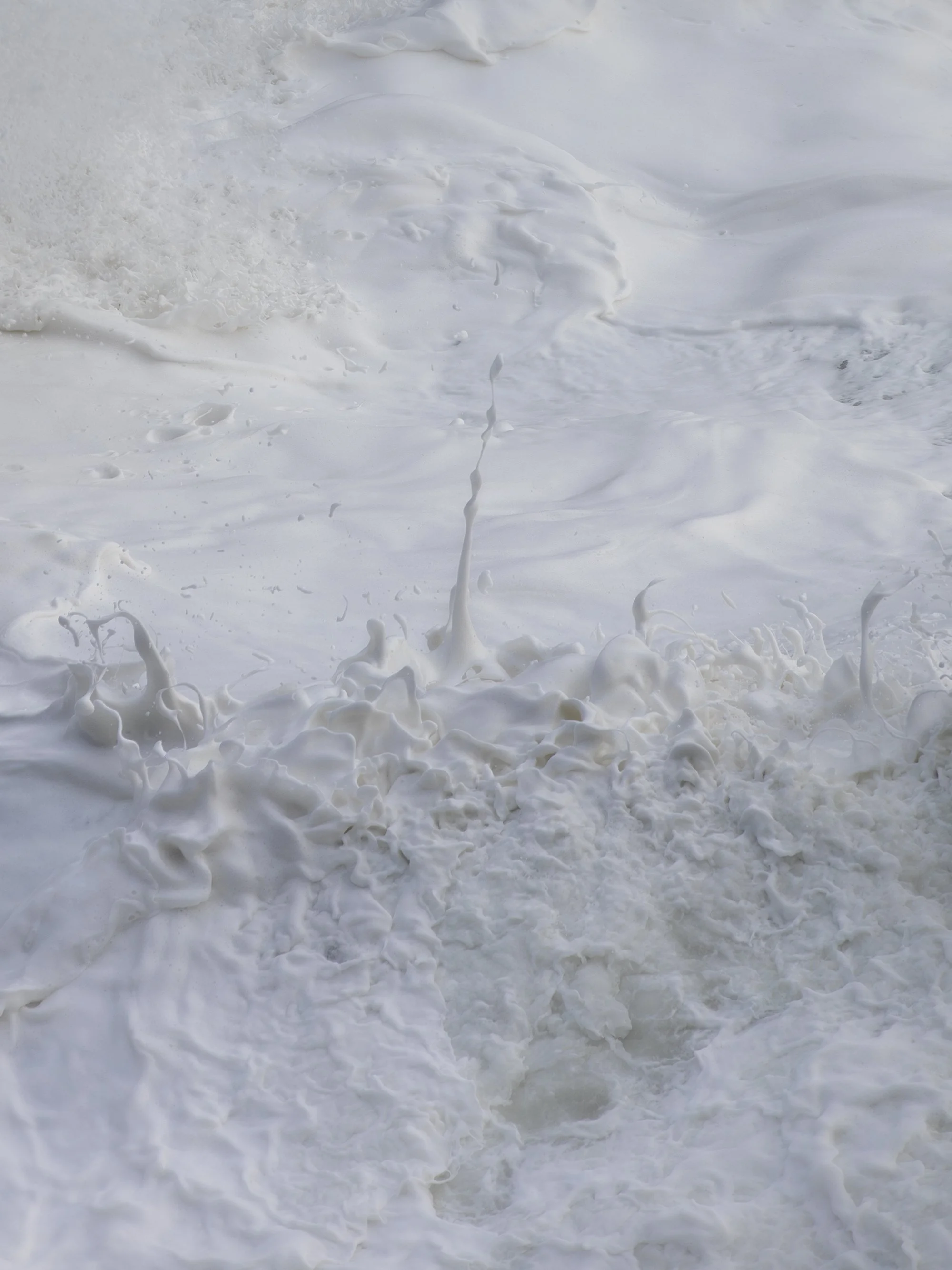 Ocean waves crashing onto the shore with white foam and sea spray.