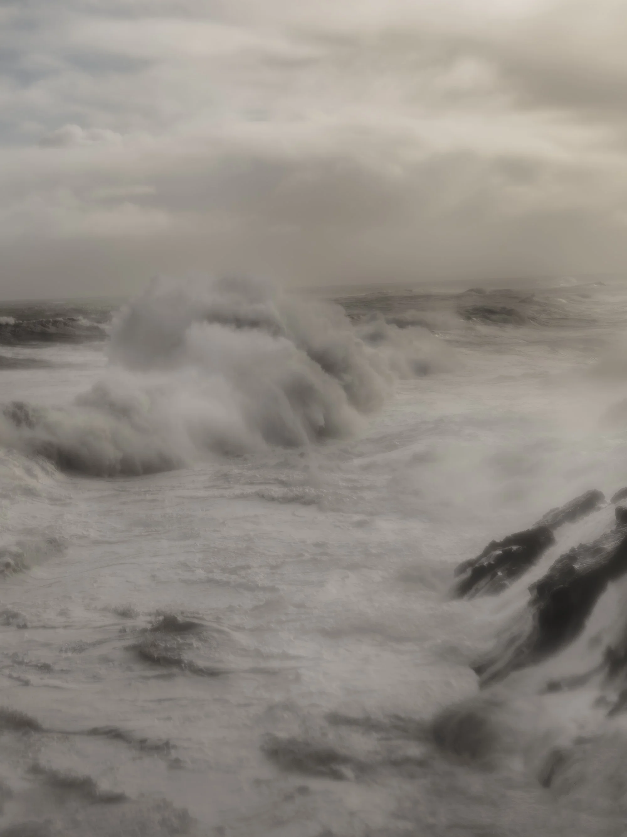 Large ocean waves crashing on a cloudy day.