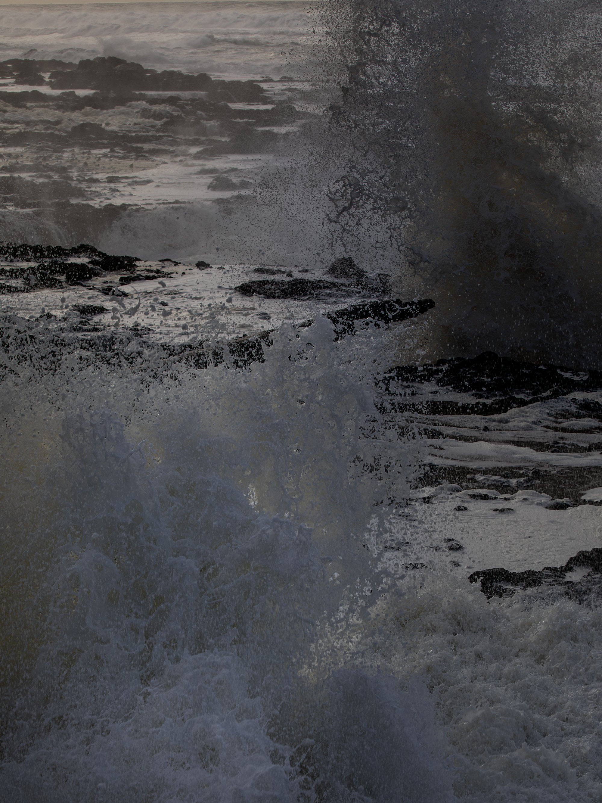 Ocean waves crashing against rocks with spray and foam.