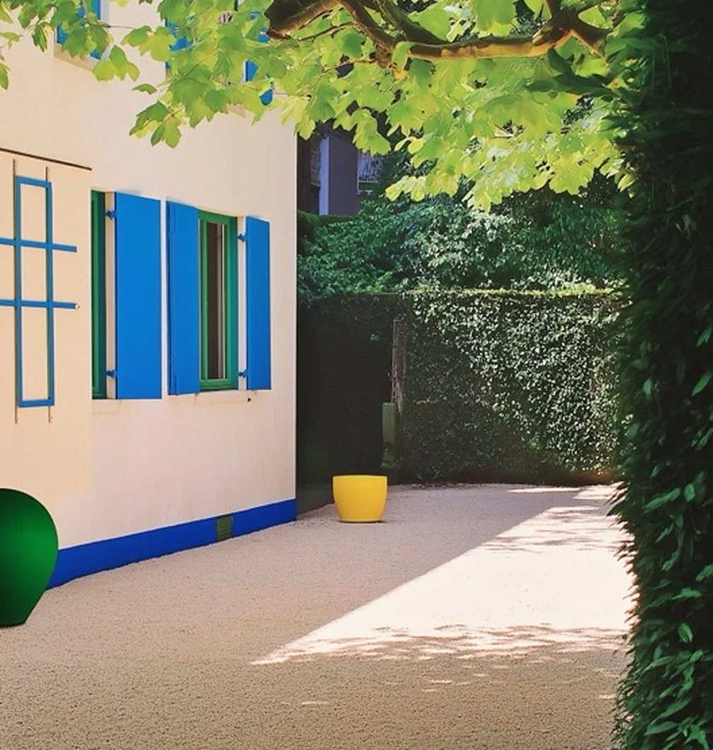 A small outdoor space with a beige gravel ground, green foliage overhead, and a wall with blue window shutters. Two large flower pots, one yellow and one green, are placed on the ground.