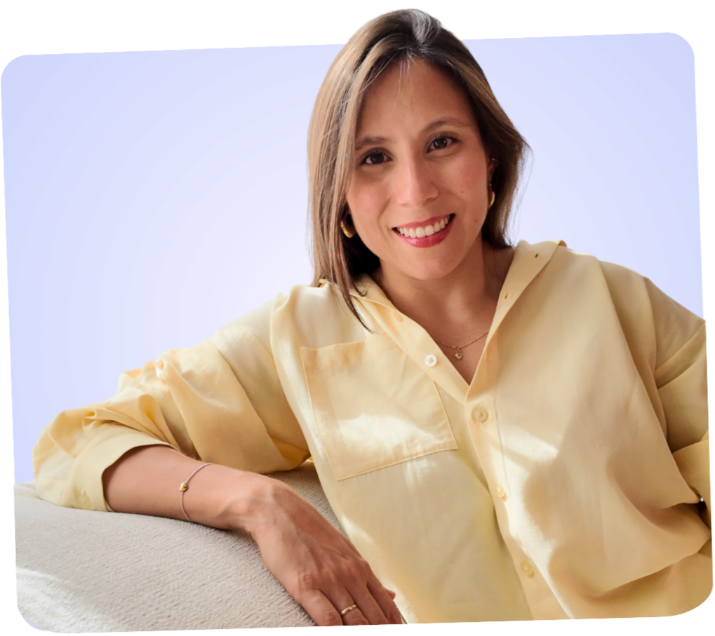 Retrato de una mujer sonriendo, con blusa amarilla y fondo lila.