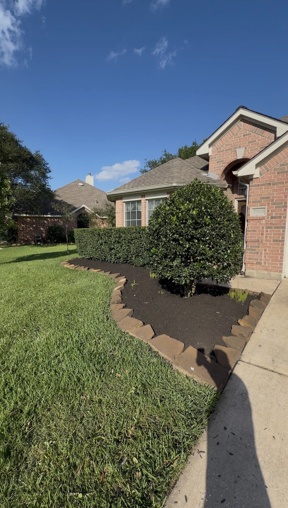 Same front yard bed after cleanup with stone border