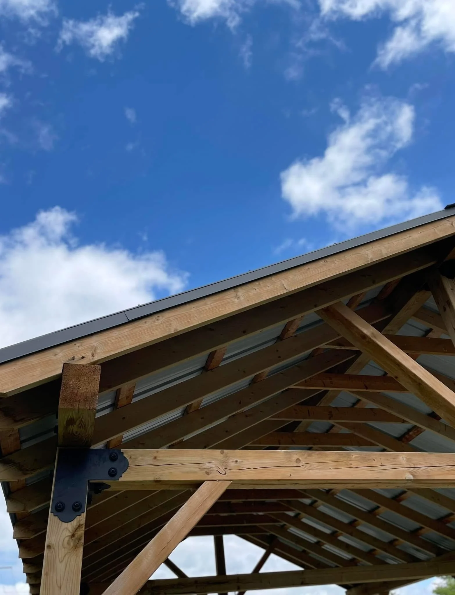 Under construction roof with wooden beams and blue sky with clouds
