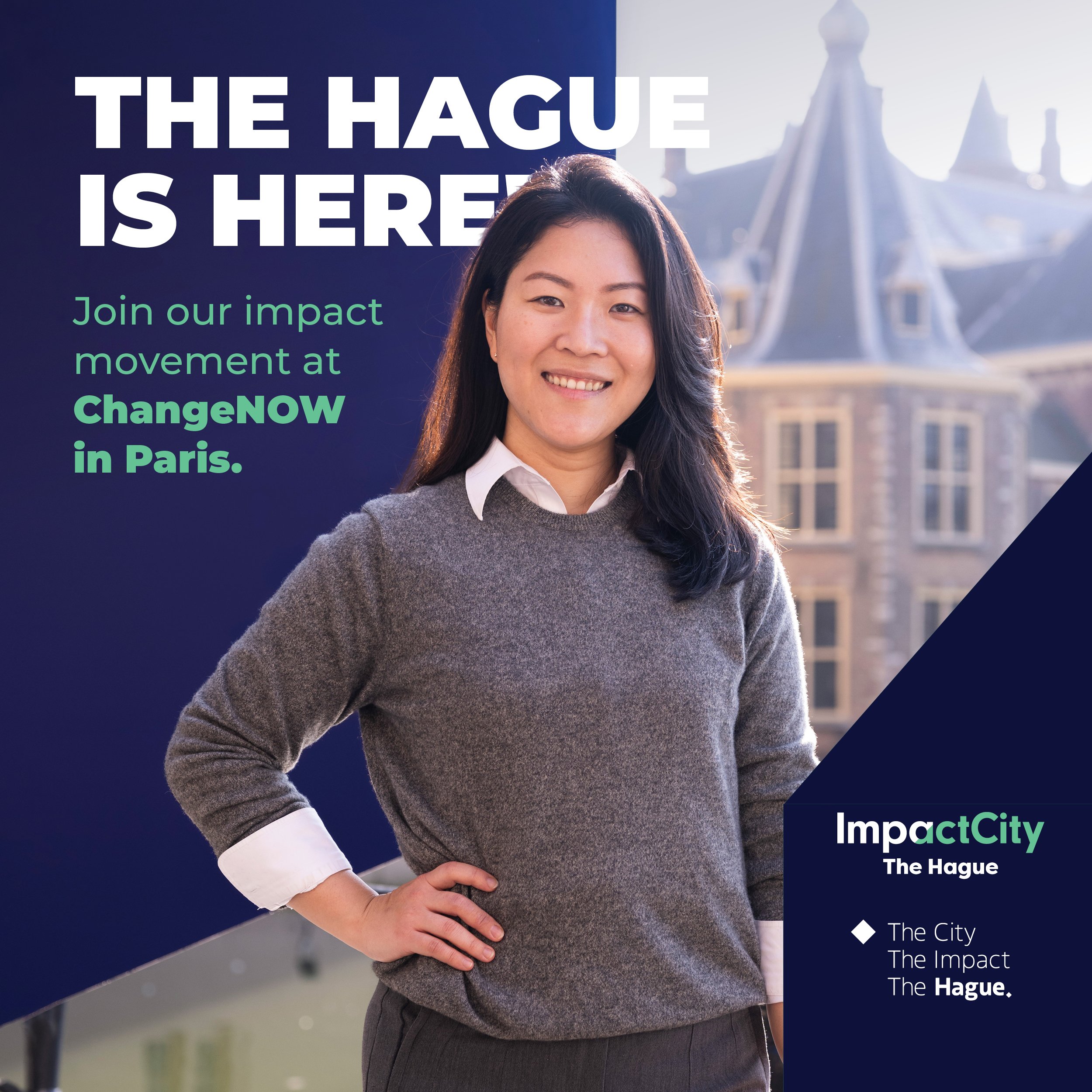 Vrouw poseert voor een campagneposter met de tekst 'The Hague is here'.