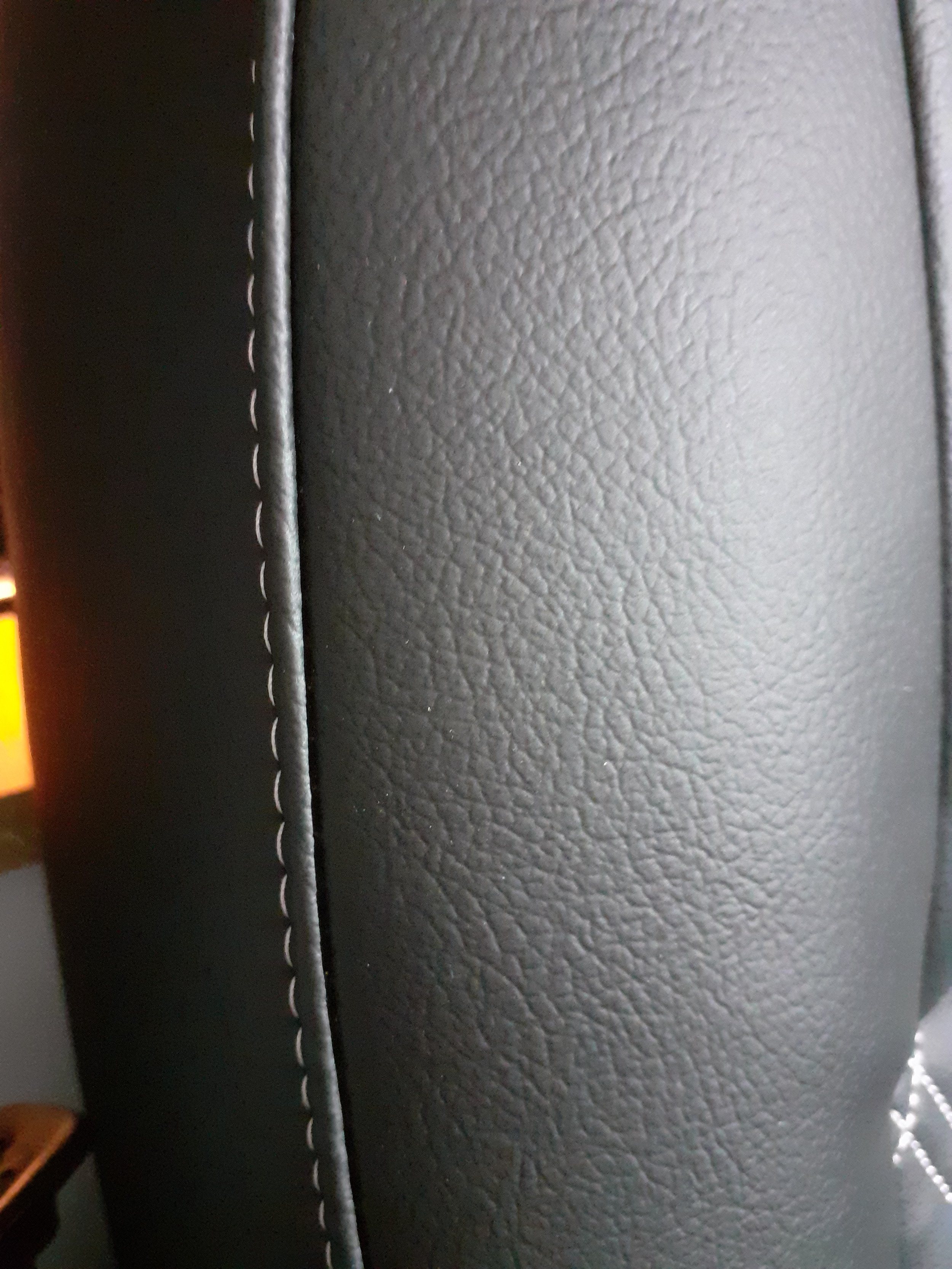 Close-up view of black leather upholstery with detailed stitching.