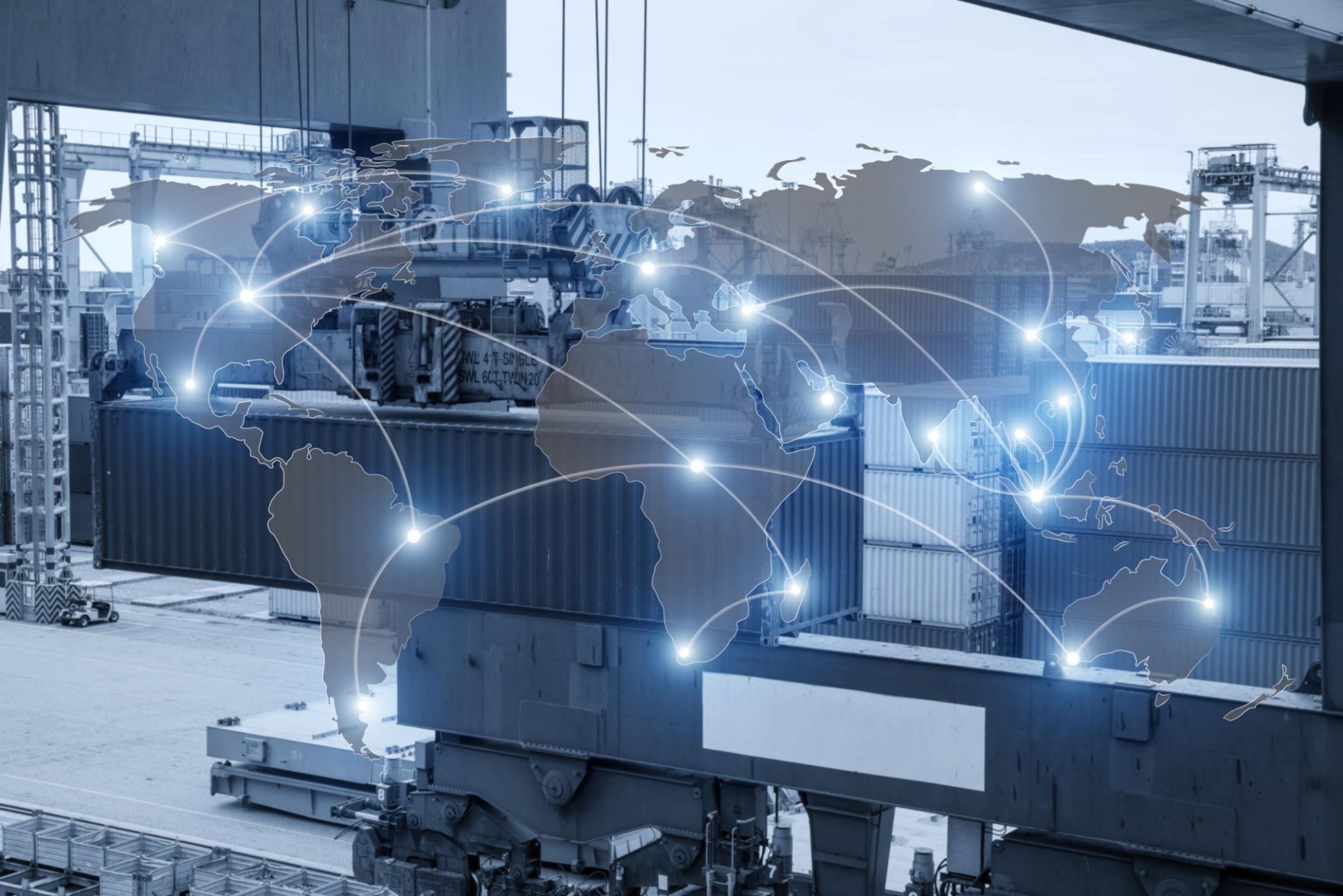 Cargo containers stacked at an industrial port with a digital overlay of a world map and connected points indicating global logistics.