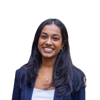 A young woman smiling with long dark hair, wearing a navy blazer over a white top.