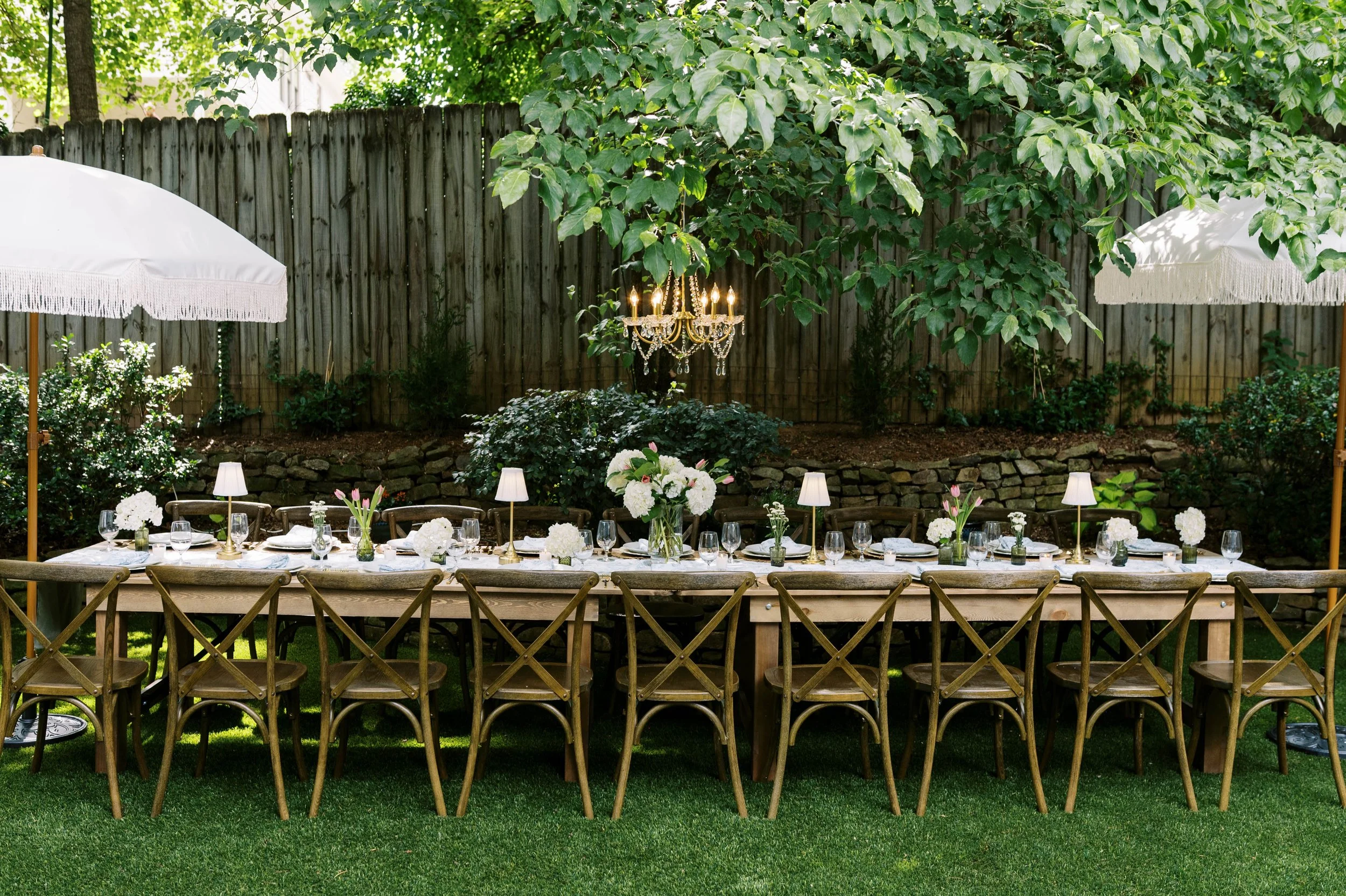 Al fresco dinner party tablescape with sage green and white linens — Atlanta boutique rentals
