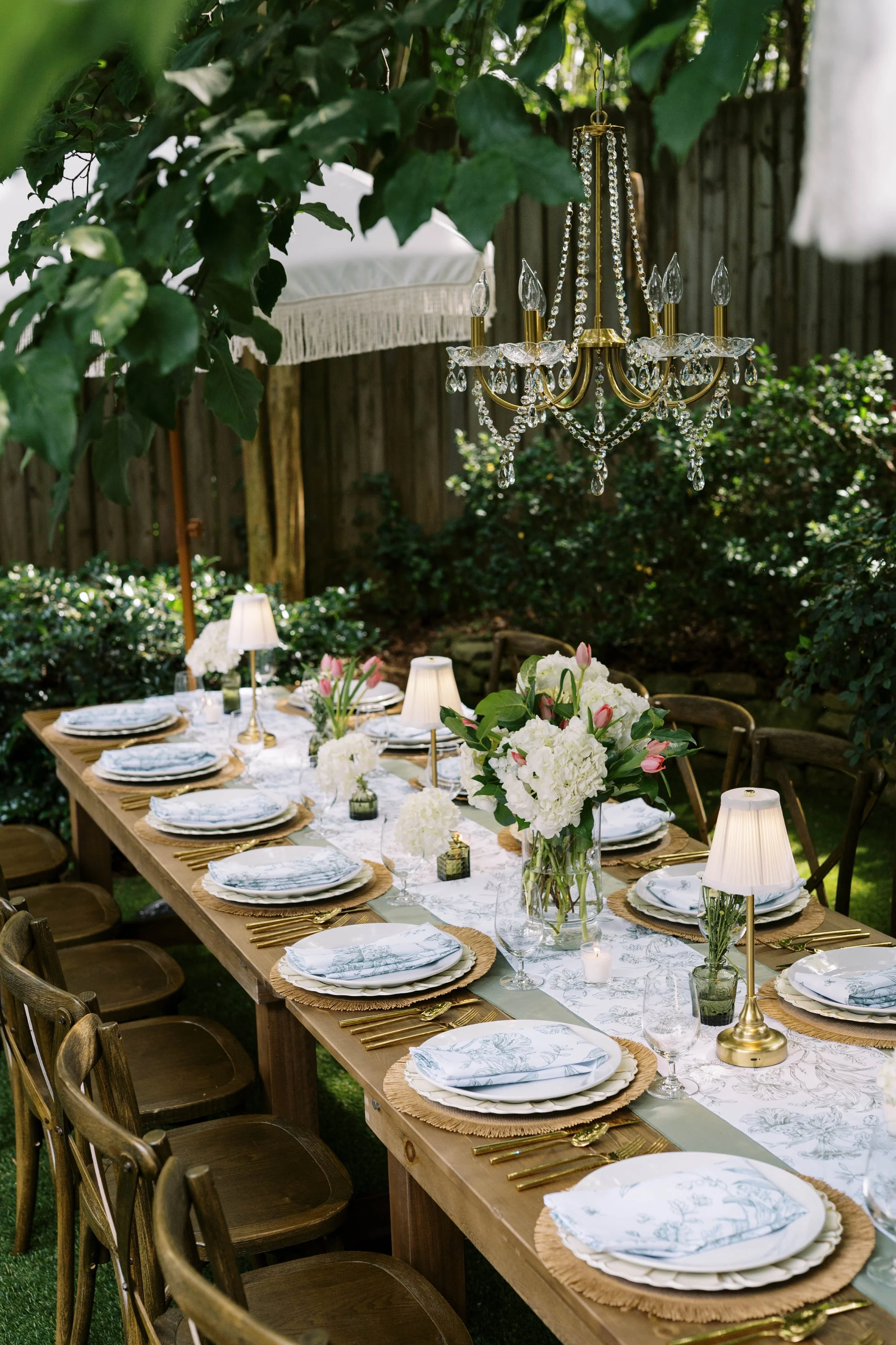 Farmhouse table styled with candles, greenery, and mixed tableware — intimate event rentals Decatur