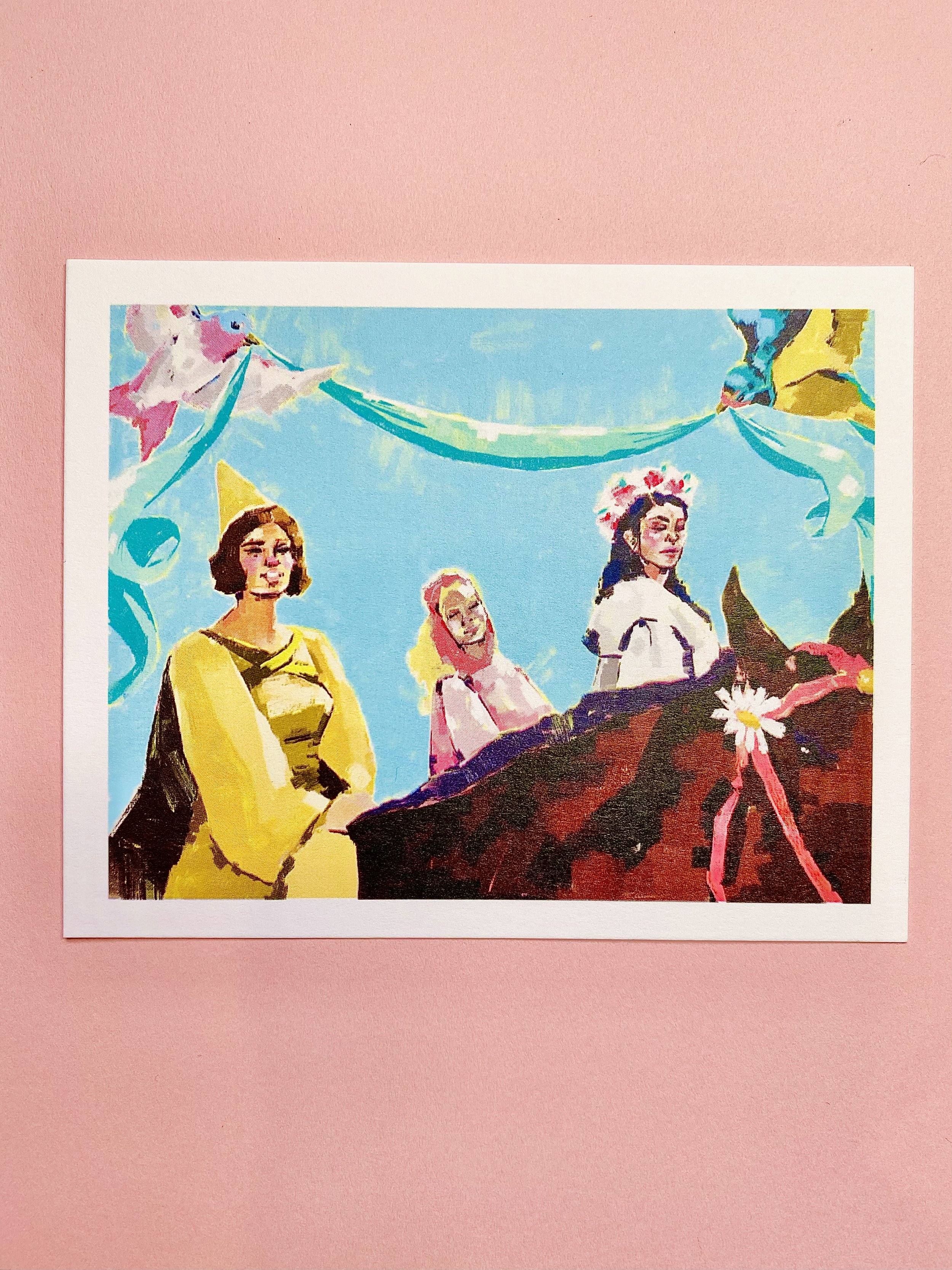 Colorful painting of three women dressed in traditional Mexican folk dresses with sombreros, standing under a blue sky. The image is displayed on a pink background.