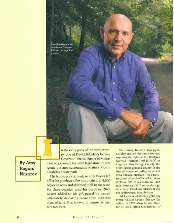 Photograph of a man in a blue shirt sitting outdoors on a wooded trail. Text overlay mentions David Brickley working on the Dahlgren Railroad Heritage Trail.