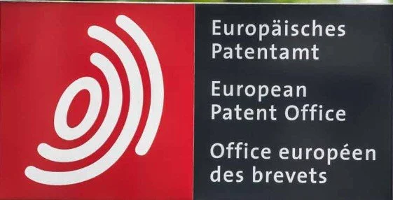 Schild des Europäischen Patentamts mit Logo und Text in Deutsch, Englisch und Französisch.