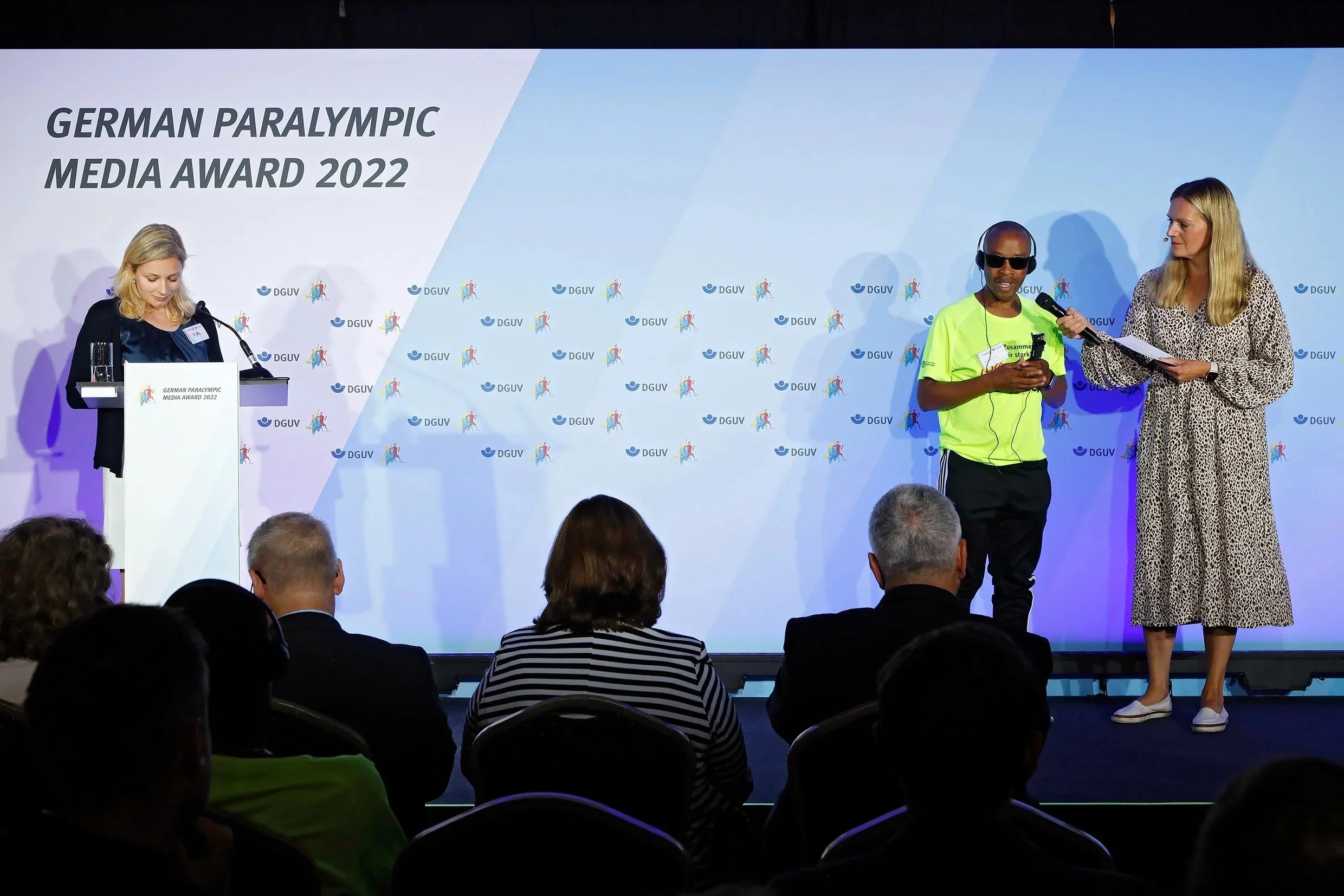 Konferenzdolmetscherin Michelle Effer bei der Konsekutivverdolmetschung einer Laudatio während einer Preisverleihung auf der Bühne.