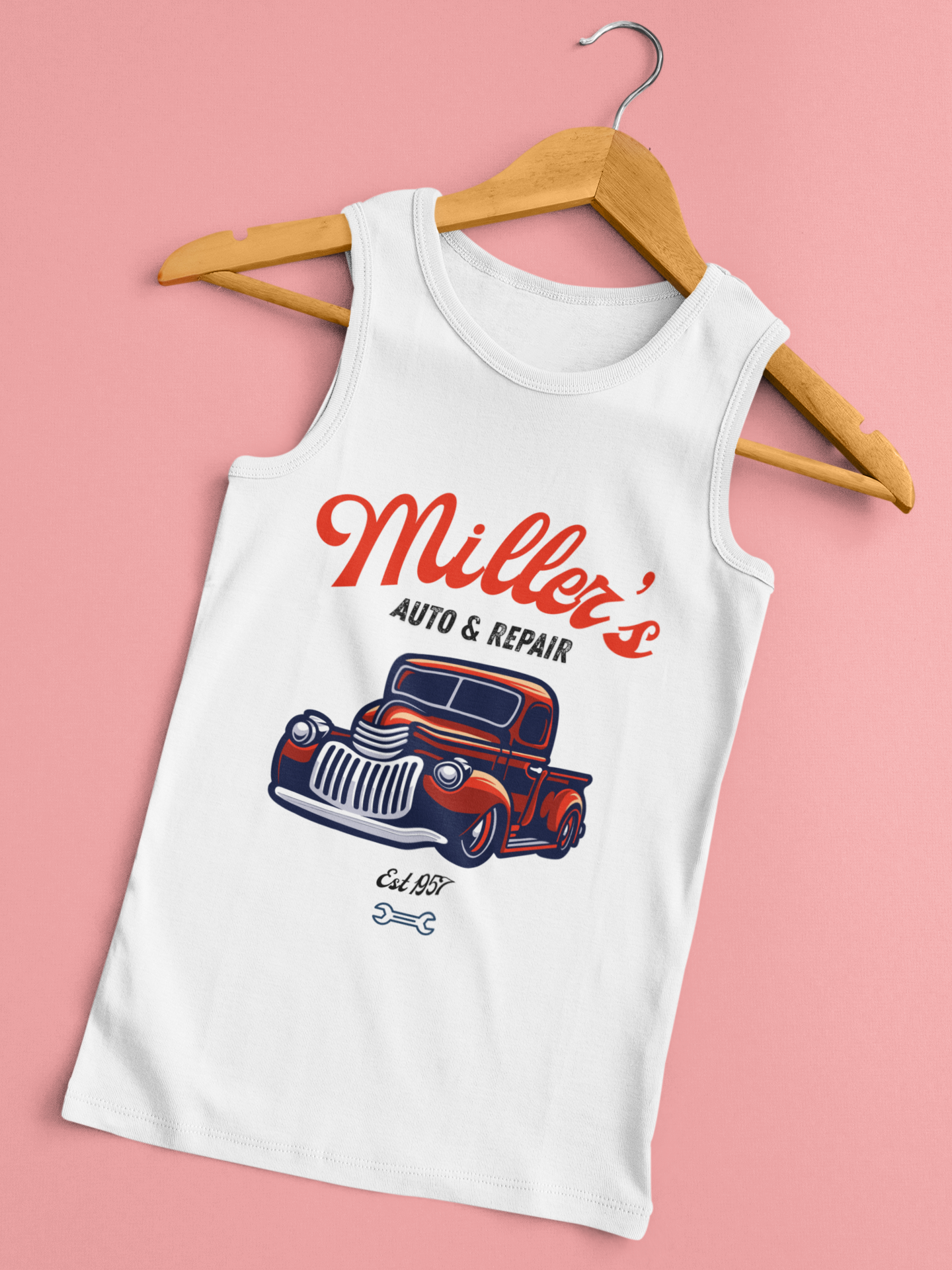 White sleeveless tank top with a vintage car graphic, the text "Miller's Auto & Repair," and "Est 1957" on a pink background. Hanged on a wooden hanger.