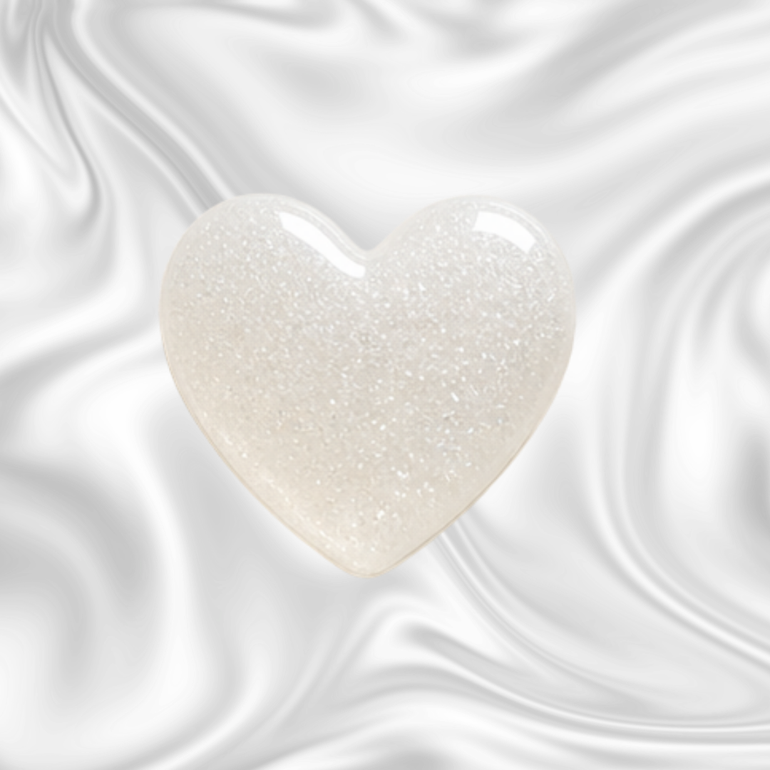 White heart-shaped object with a glittery surface on a black swirling background.