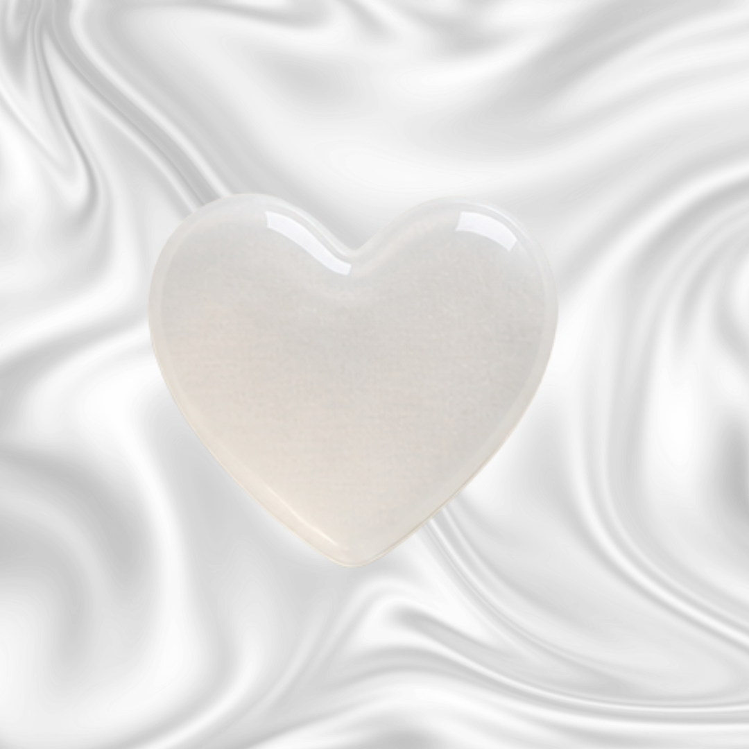 A white, glossy heart-shaped object against a black and gray marbled background.