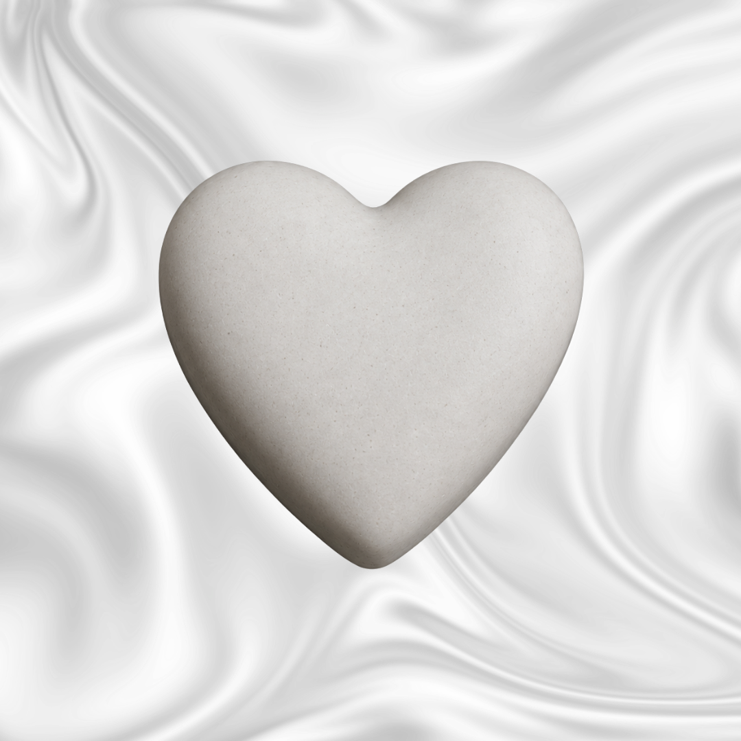 A white heart-shaped stone on a black and gray marbled background.